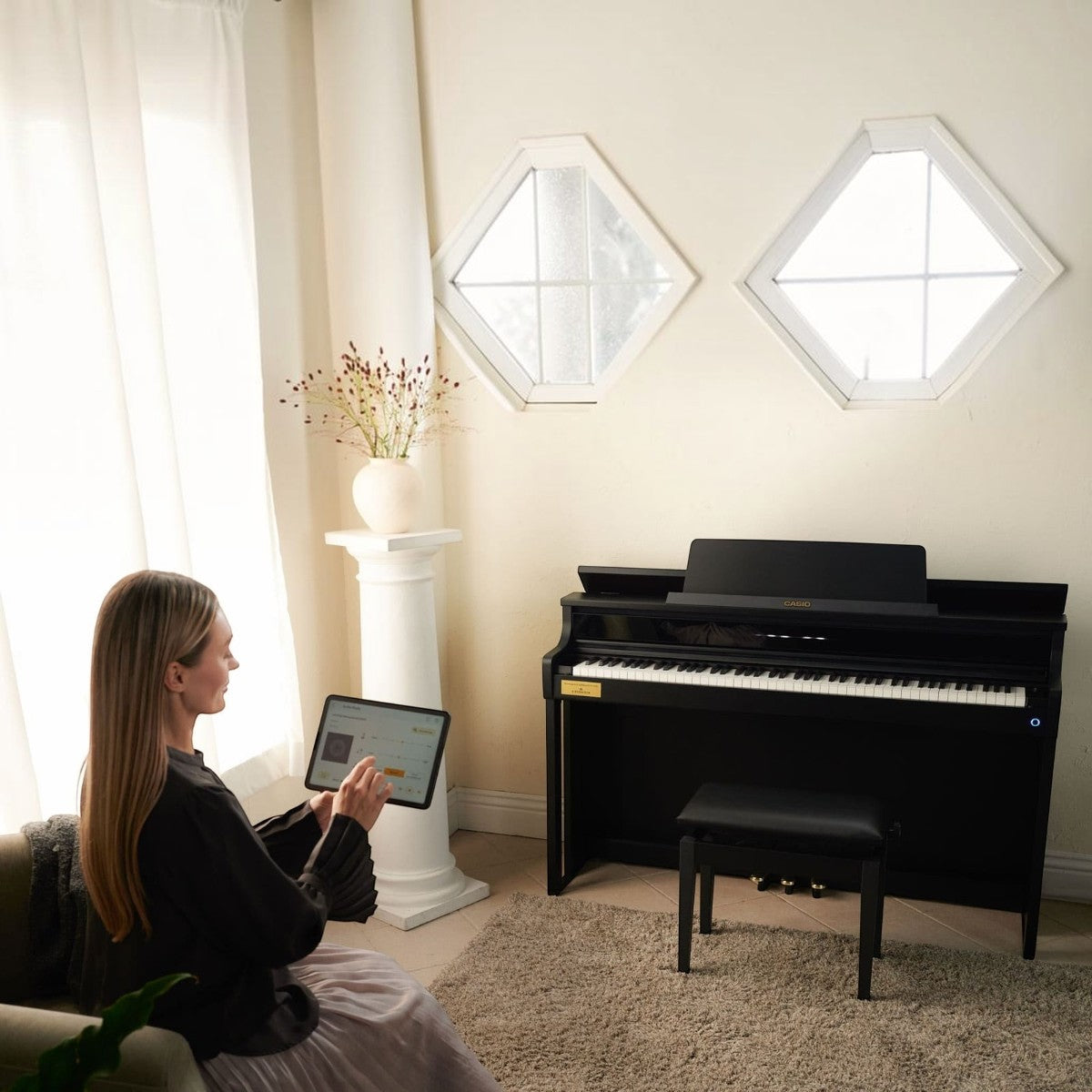Người phụ nữ sử dụng máy tính bảng kết nối với đàn piano điện Casio AP-750 màu đen tại showroom Tân Nhạc Cụ