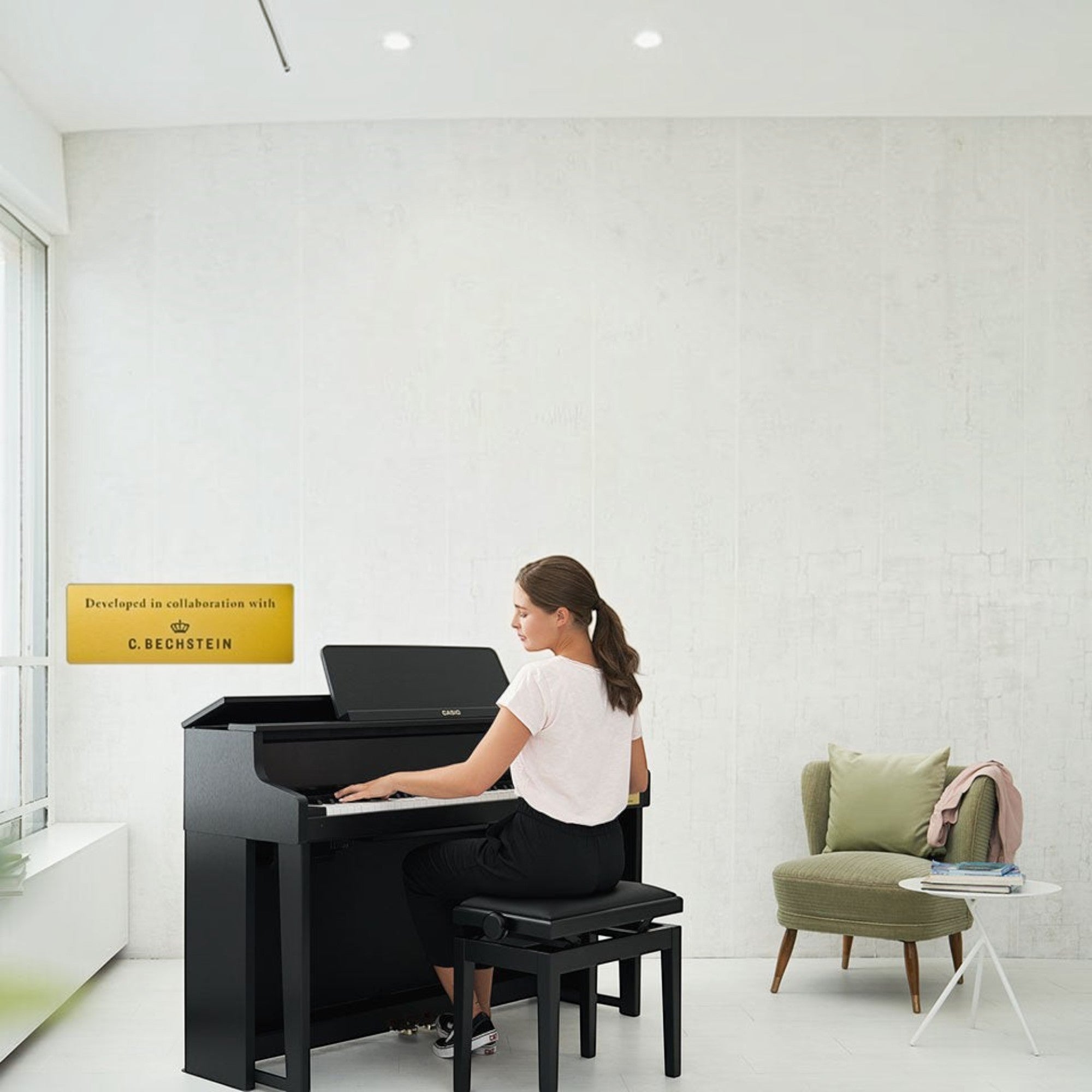 Người phụ nữ đang chơi đàn piano điện Casio GP-310 màu đen tại showroom TÂN NHẠC CỤ với thiết kế phím gỗ búa cơ thật.
