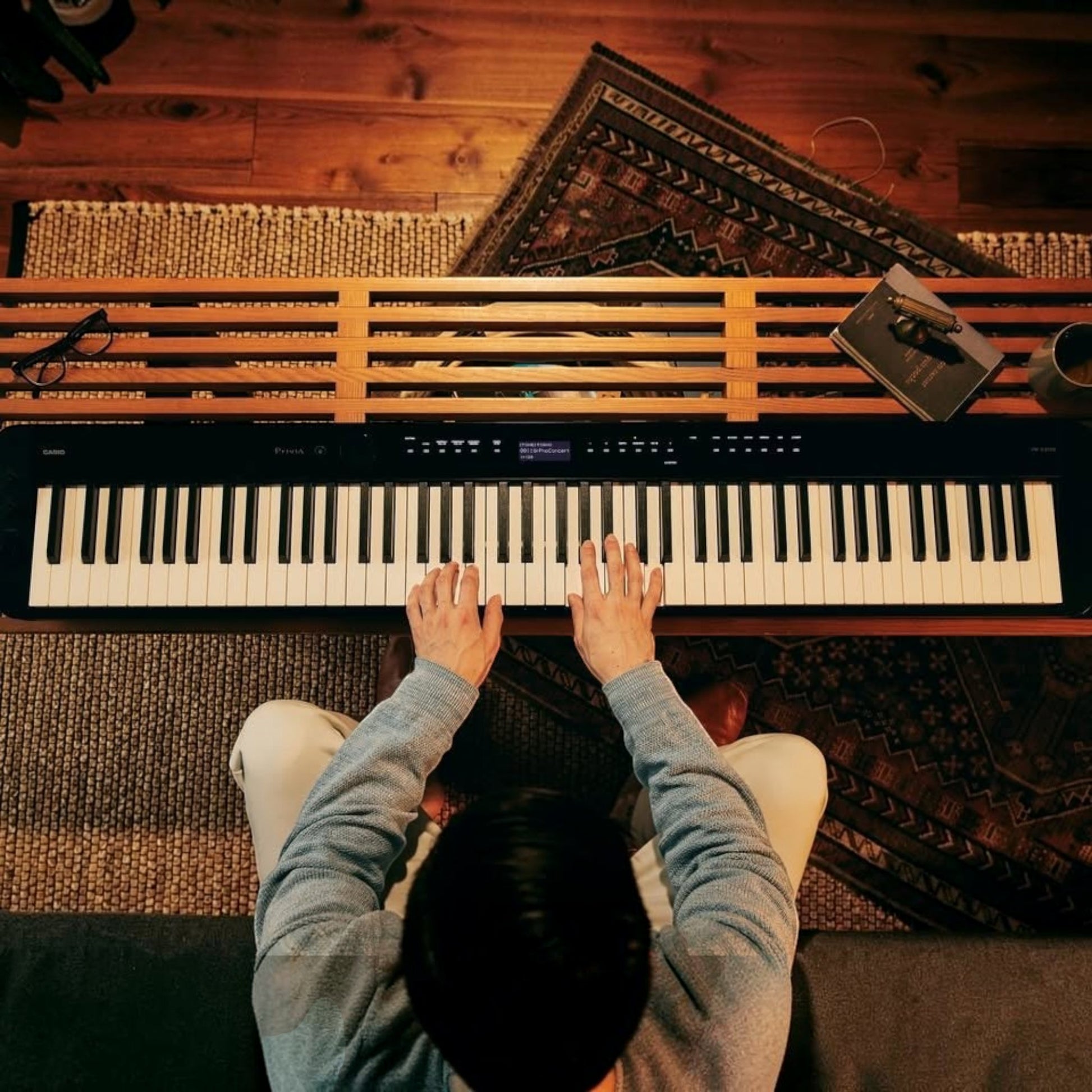 Người chơi đàn piano điện Casio PX-S3100 màu đen mỏng gọn tại Tân Nhạc Cụ với không gian nội thất ấm cúng