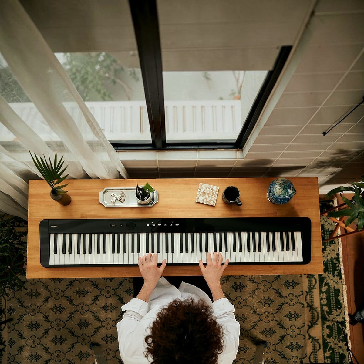 Người chơi đàn piano điện Casio PX-S5000 màu đen với bàn phím gỗ-nhựa composite tại Tân Nhạc Cụ