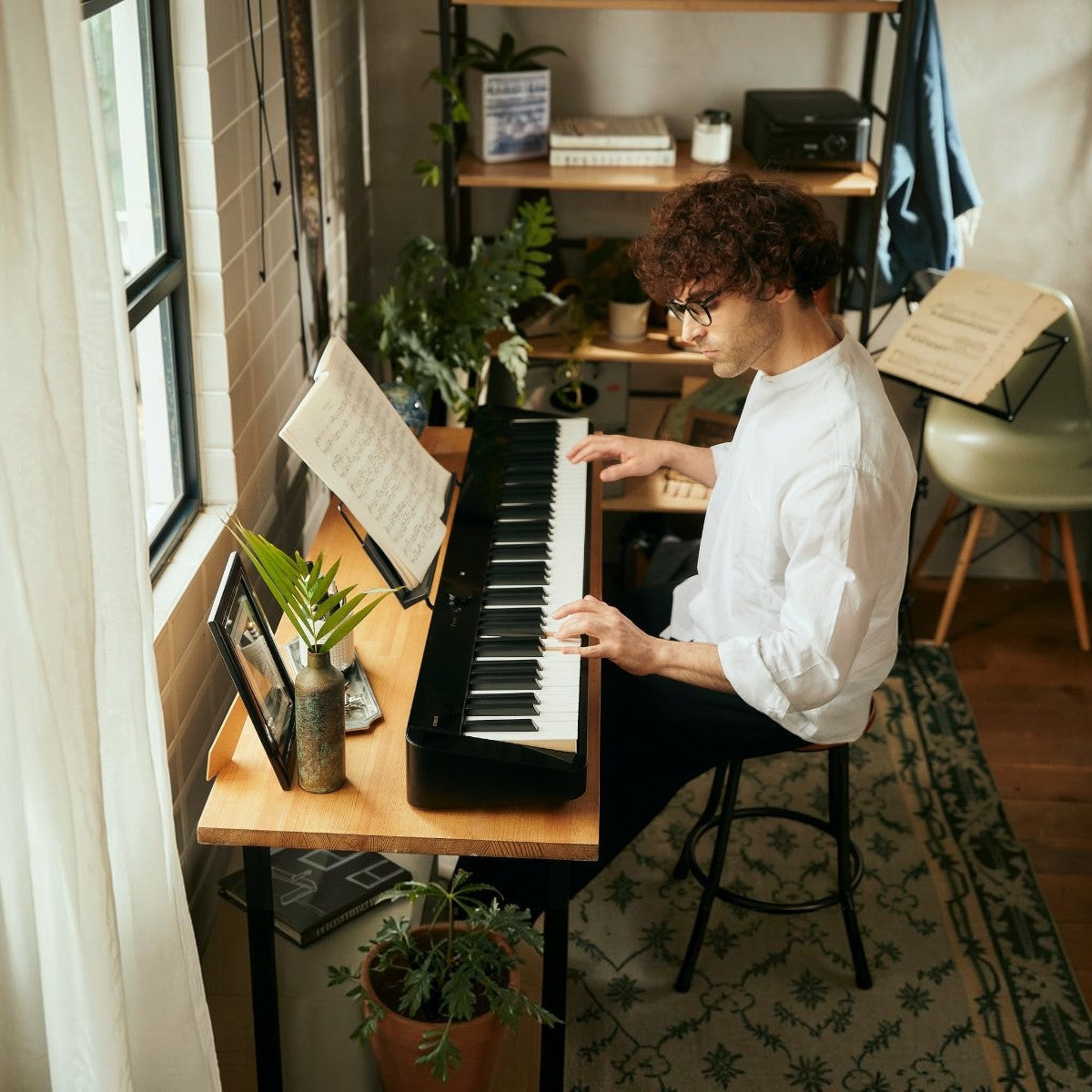 Nam nghệ sĩ chơi đàn piano điện Casio PX-S5000 màu đen với phím gỗ-nhựa composite tại không gian làm việc Tân Nhạc Cụ