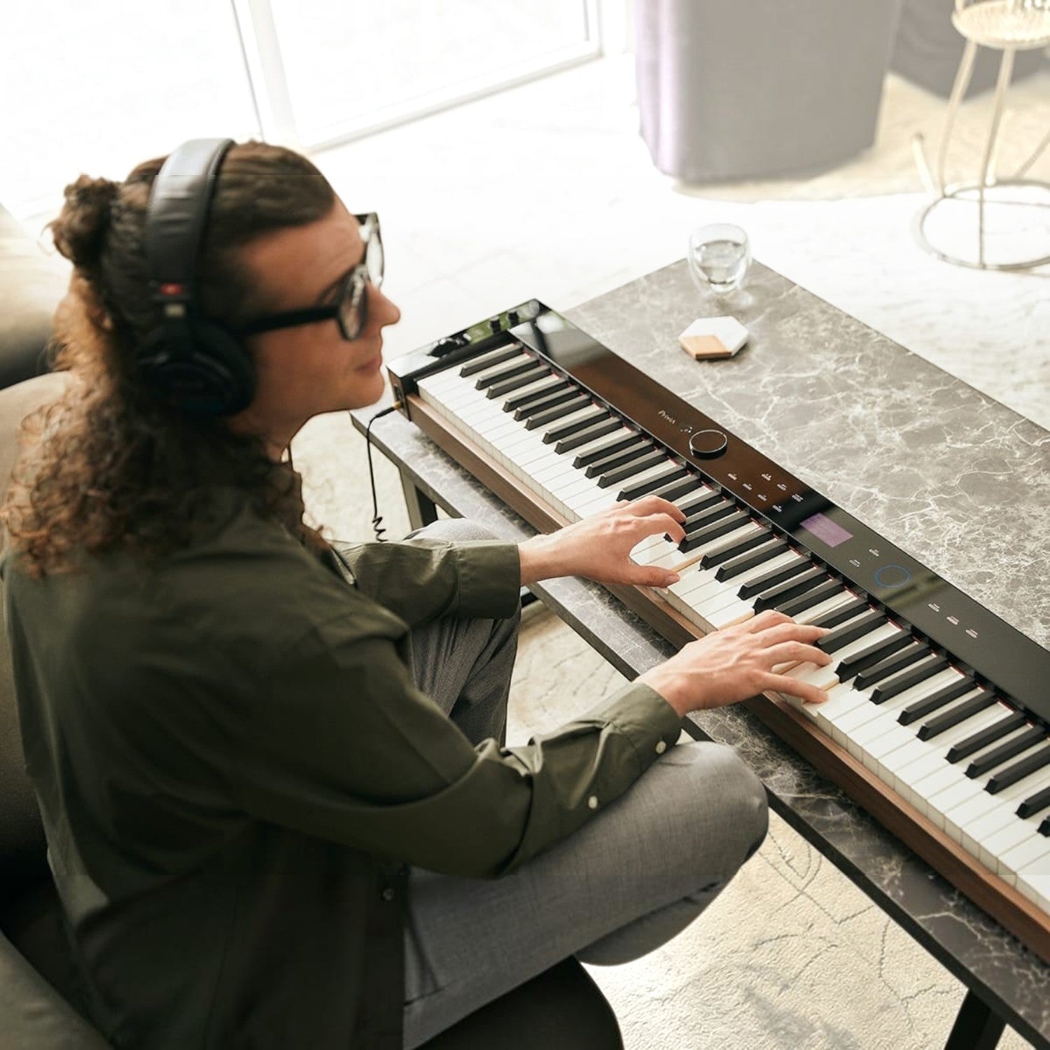 Nhạc công đeo tai nghe chơi đàn piano điện Casio PX-S6000 màu đen tại Tân Nhạc Cụ
