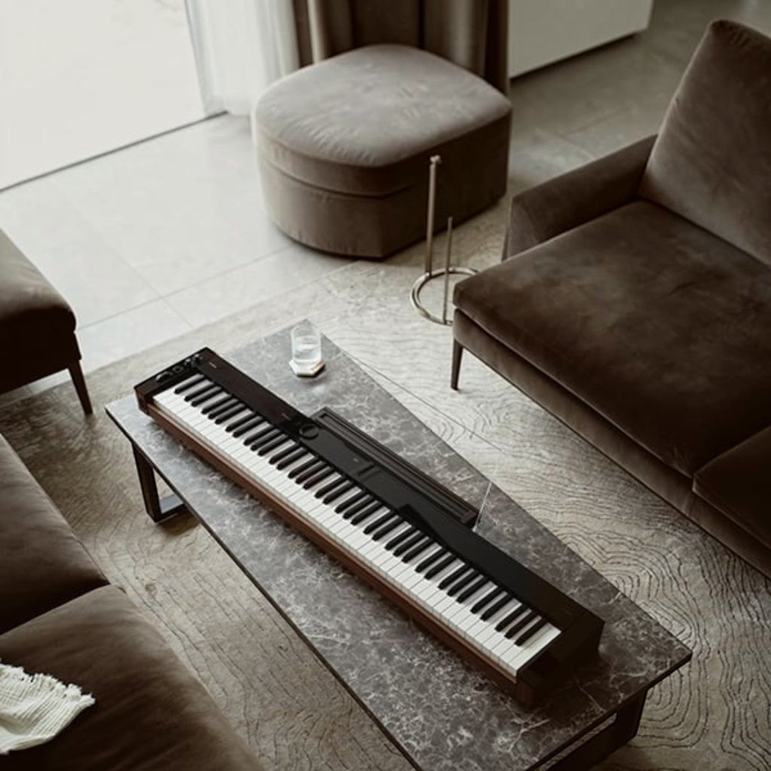 Đàn piano điện Casio PX-S6000 màu đen sang trọng đặt trên bàn đá tại showroom TÂN NHẠC CỤ