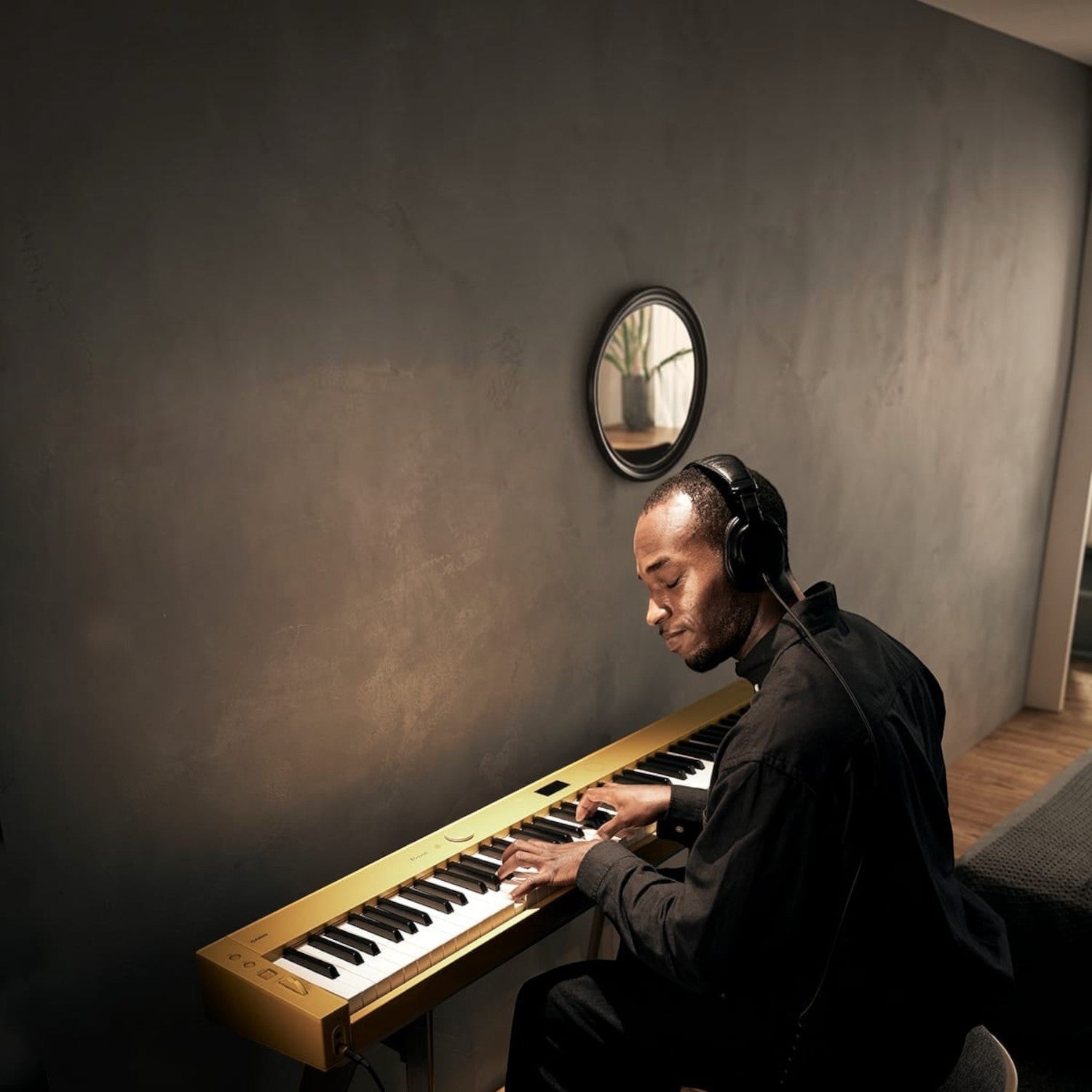 Nam nhạc sĩ đeo tai nghe chơi đàn piano điện Casio PX-S7000 màu vàng mù tạt tại TÂN NHẠC CỤ