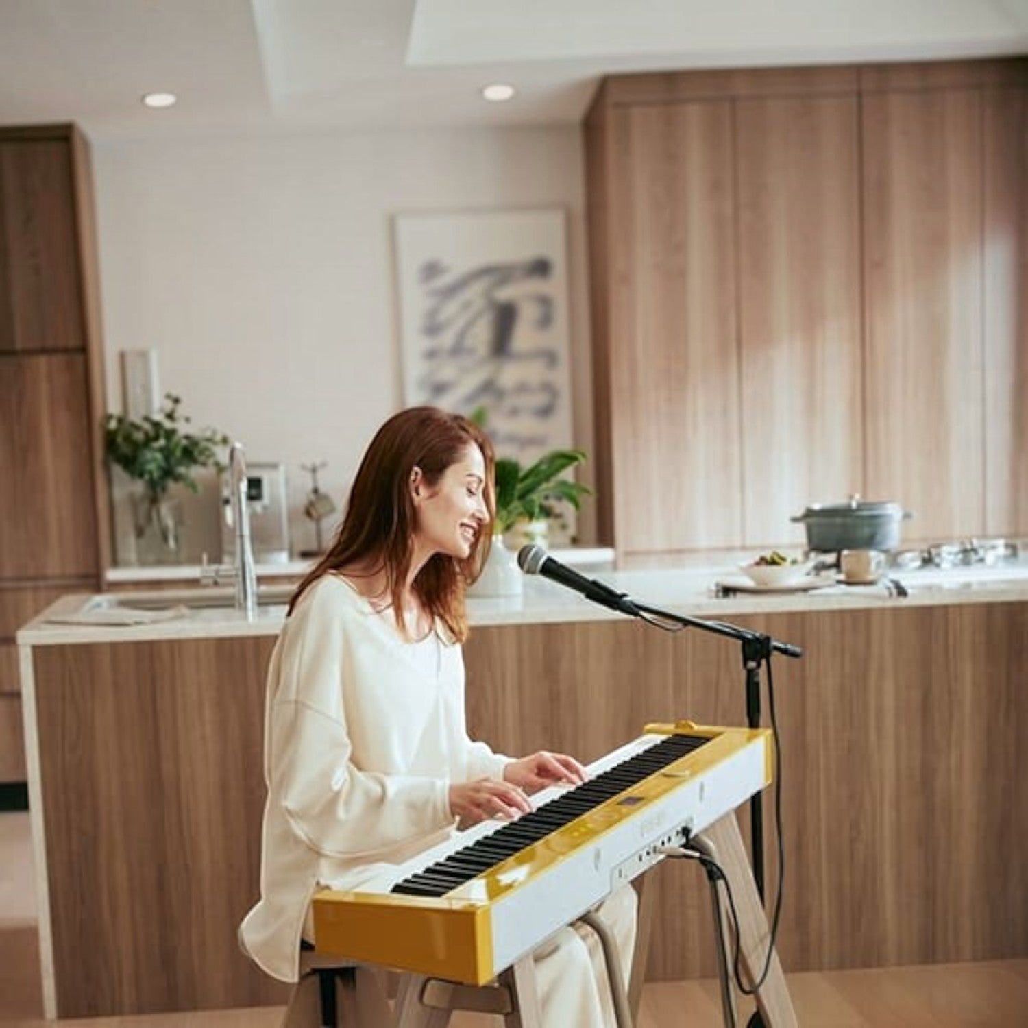 Người phụ nữ đang chơi đàn piano điện Casio PX-S7000 màu Harmonious Mustard tại nhà, có micro hát kèm, do TÂN NHẠC CỤ cung cấp