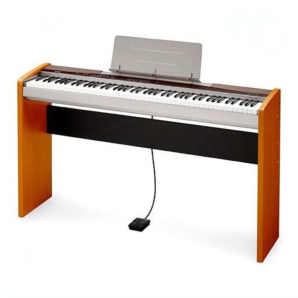 Đàn piano điện TÂN NHẠC CỤ Casio PX100 với thiết kế nhỏ gọn, bàn phím 88 phím búa và chân đế gỗ màu vàng gỗ sang trọng