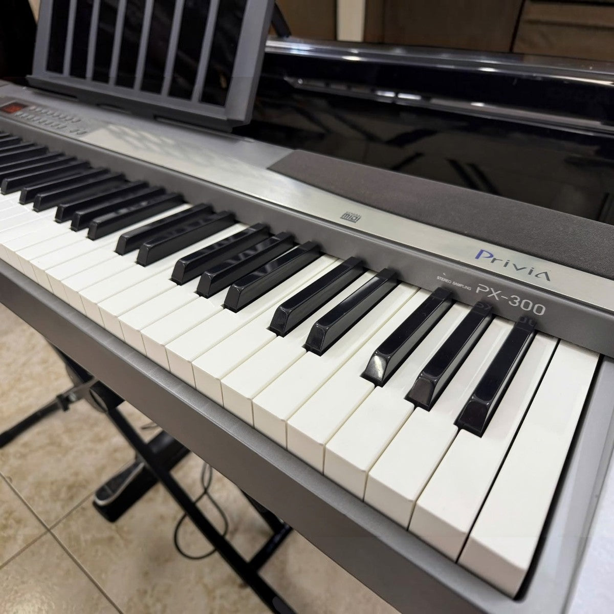 Đàn piano điện Casio PX300 tại TÂN NHẠC CỤ với bàn phím búa 88 phím, thiết kế màu xám bạc hiện đại và chuyên nghiệp