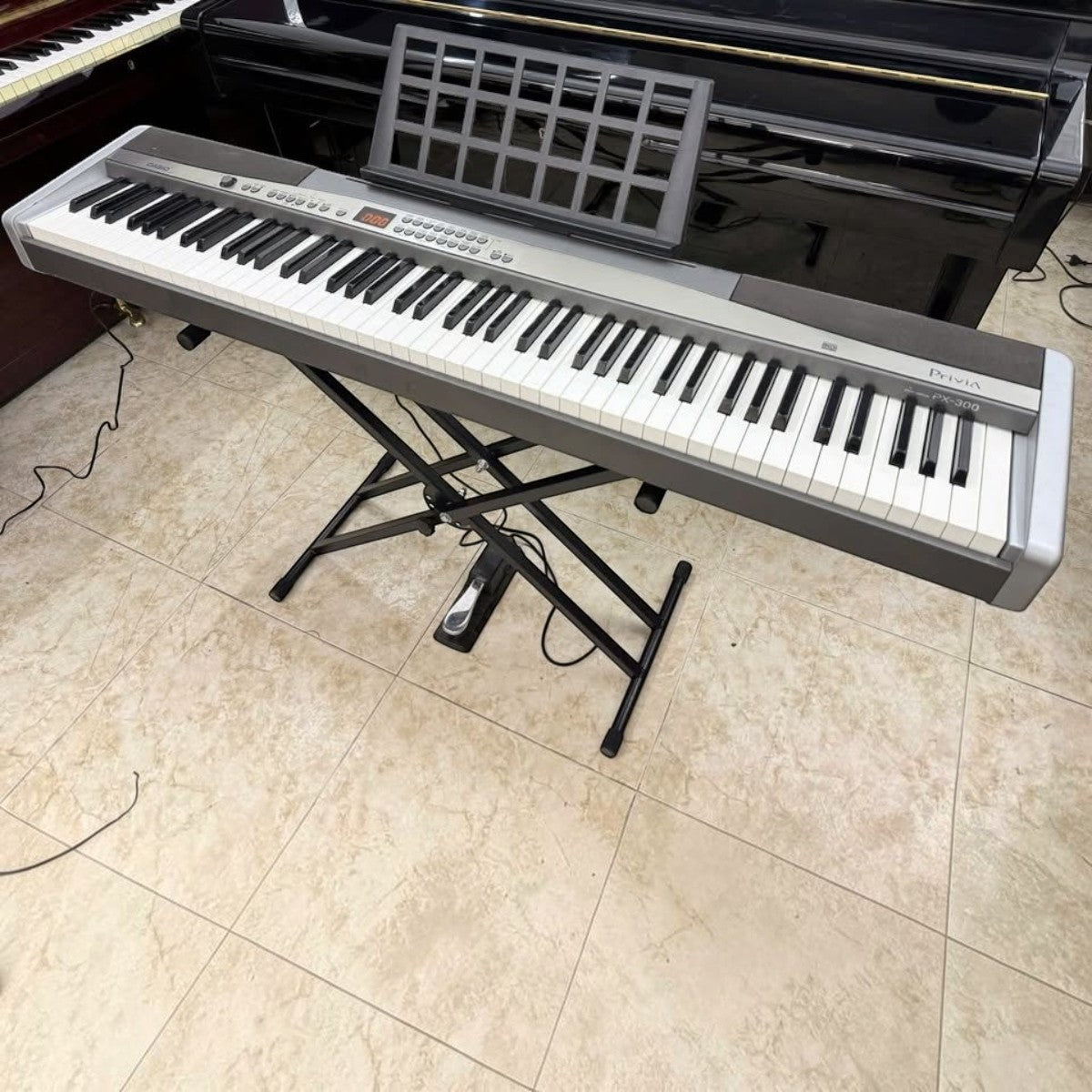 Đàn piano điện Casio PX300 tại TÂN NHẠC CỤ với 88 phím búa, thiết kế màu bạc sang trọng trên chân đế chữ X