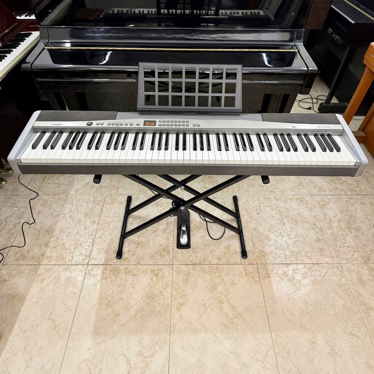 Đàn piano điện Casio PX300 tại TÂN NHẠC CỤ với bàn phím 88 phím búa, thiết kế màu bạc sang trọng trên chân đế chữ X