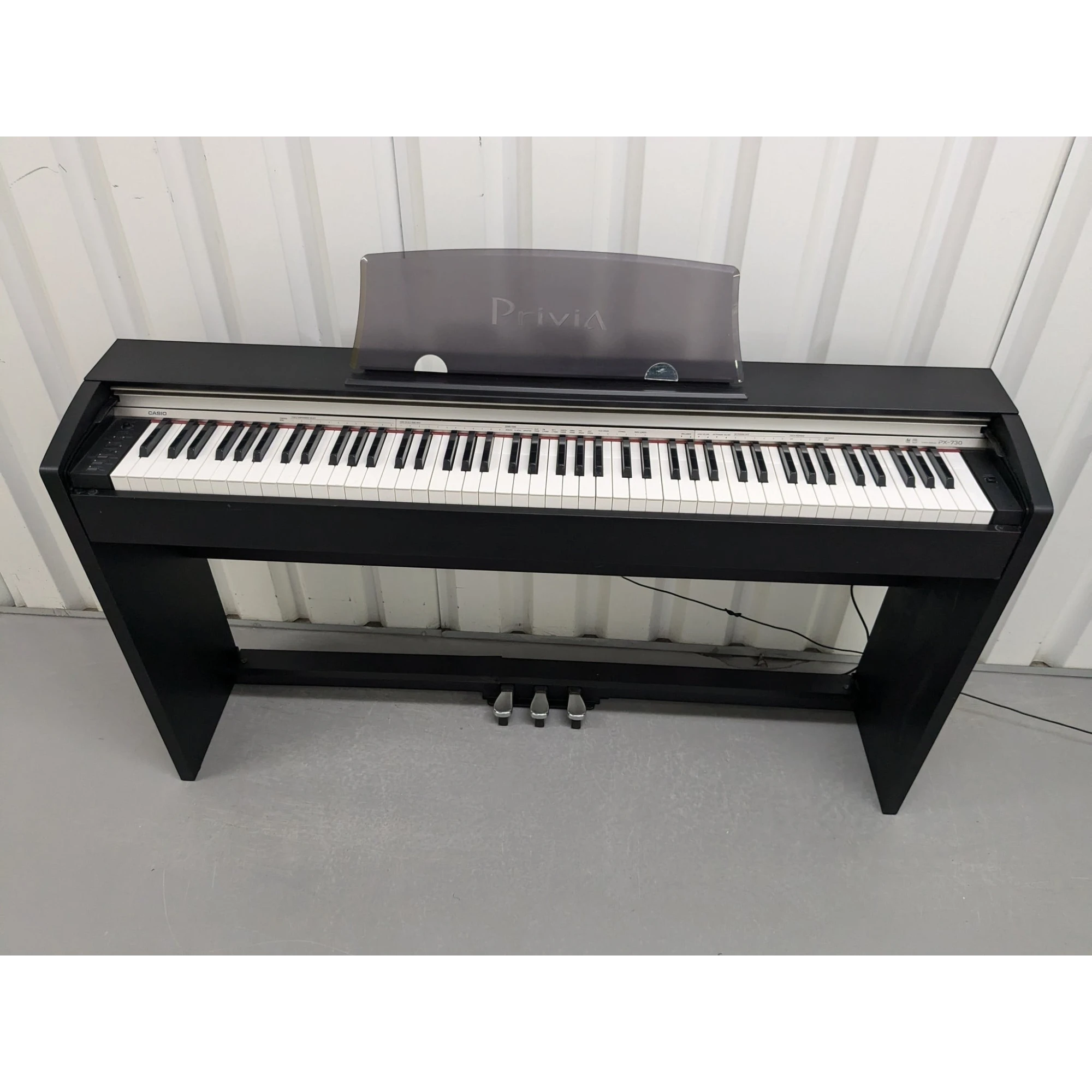 Đàn piano điện Casio PX-730 cũ màu đen tại Tân Nhạc Cụ với thiết kế dáng tủ gọn gàng và bàn phím búa 88 phím.