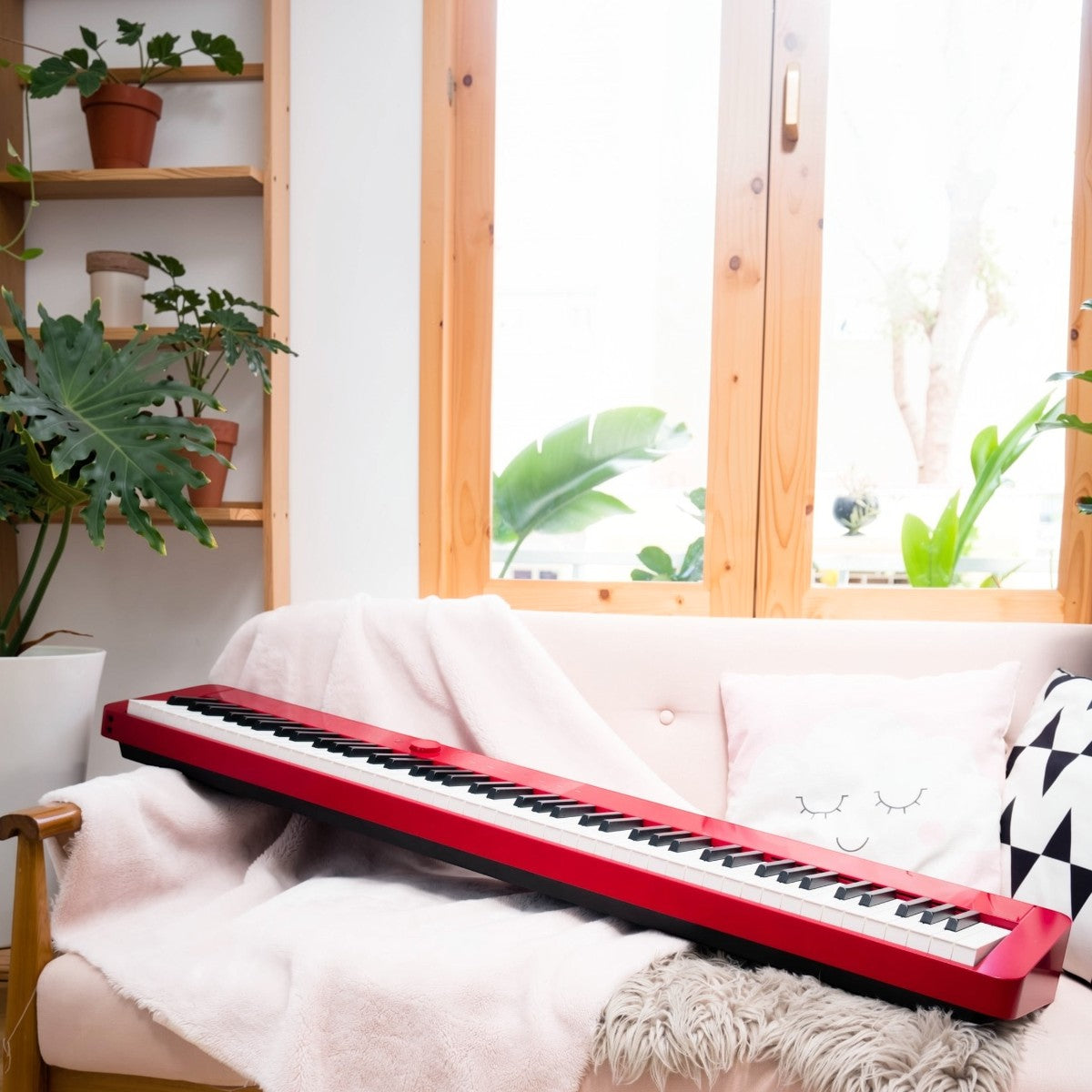 Đàn piano điện Casio PX-S1000 màu đỏ siêu mỏng đặt trên ghế sofa tại TÂN NHẠC CỤ