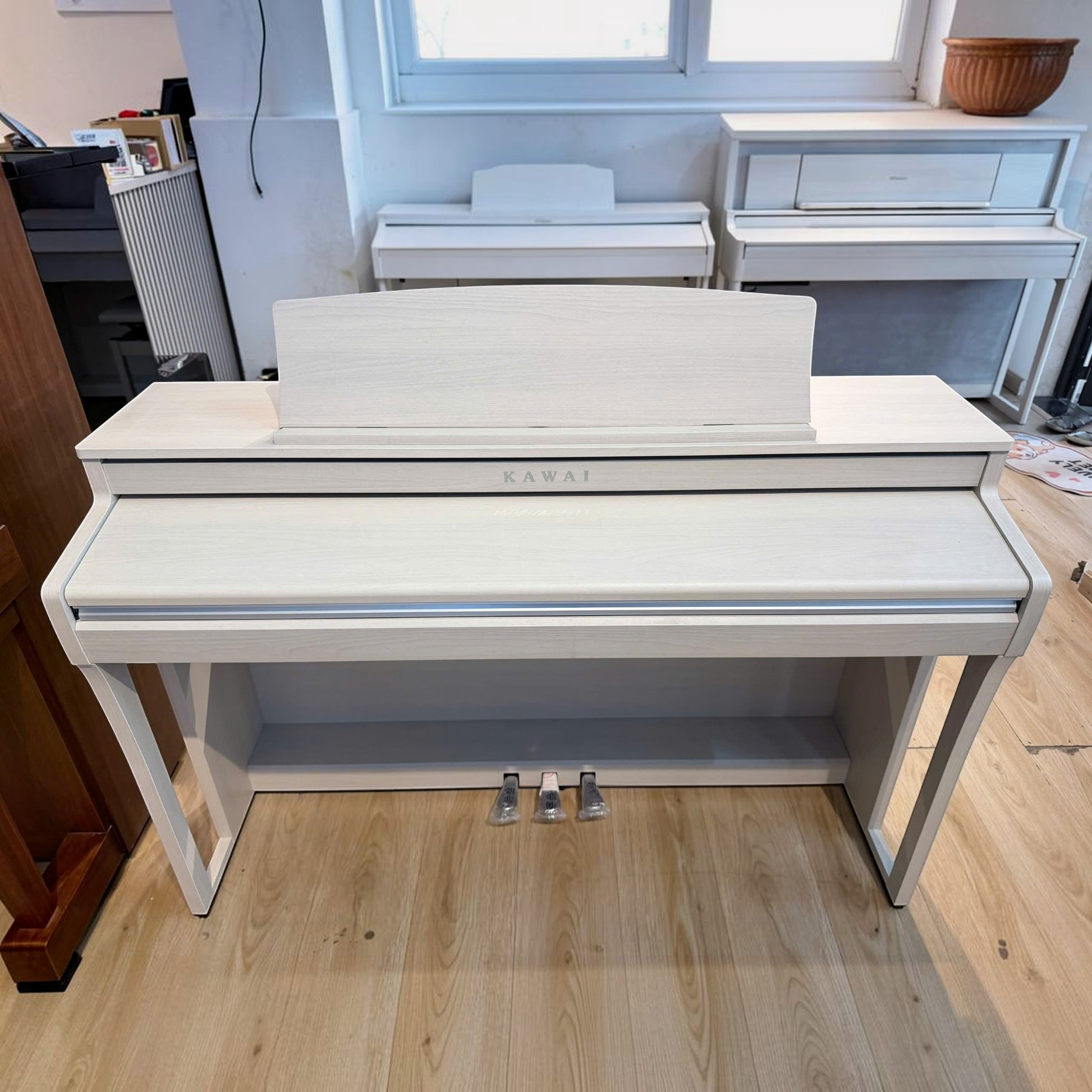 Đàn piano điện Kawai CA49 màu trắng tại Tân Nhạc Cụ, dáng tủ sang trọng với bàn phím gỗ Grand Feel Compact cao cấp.