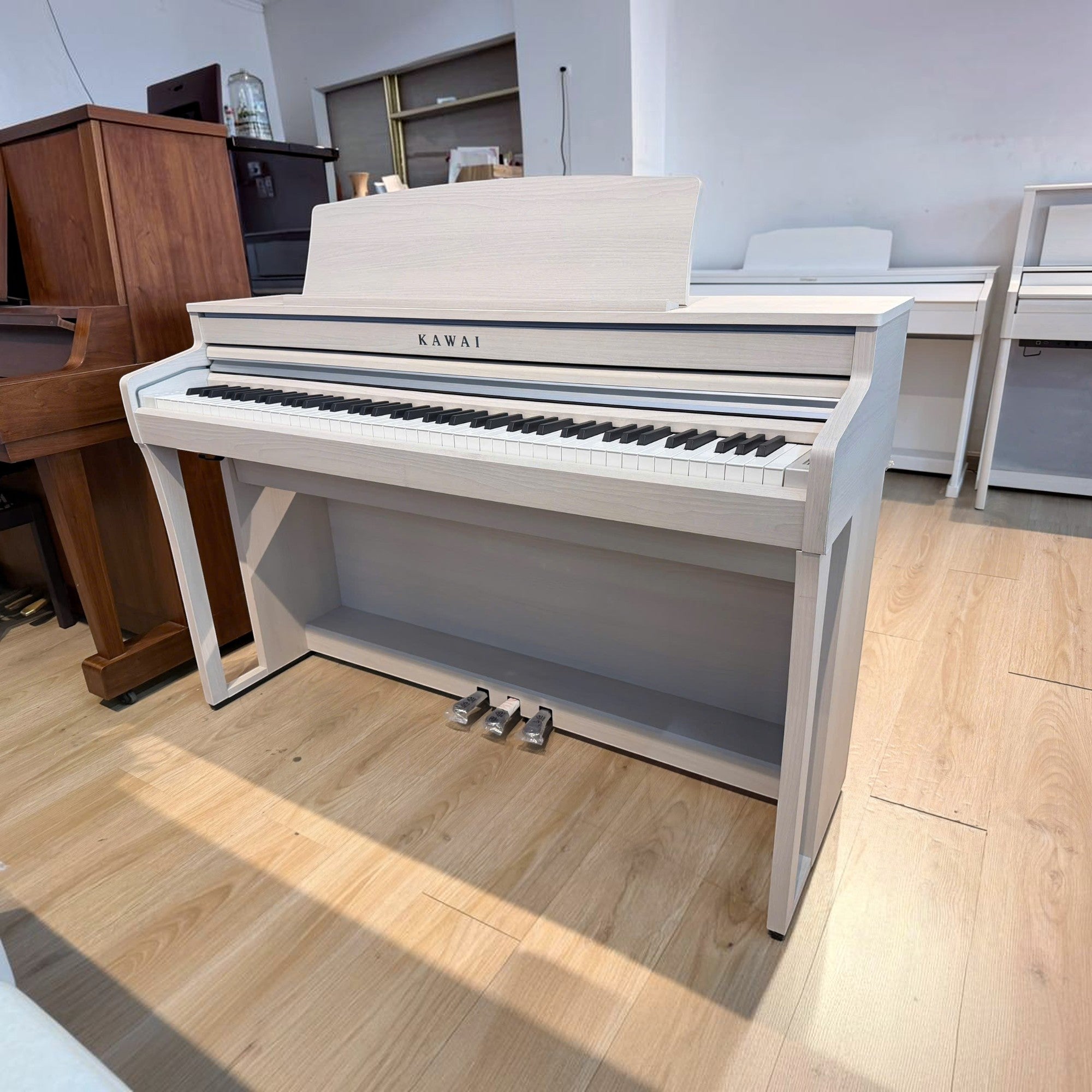 Đàn piano điện Kawai CA49 màu trắng tại TÂN NHẠC CỤ, dáng tủ sang trọng với bàn phím gỗ Grand Feel Compact.