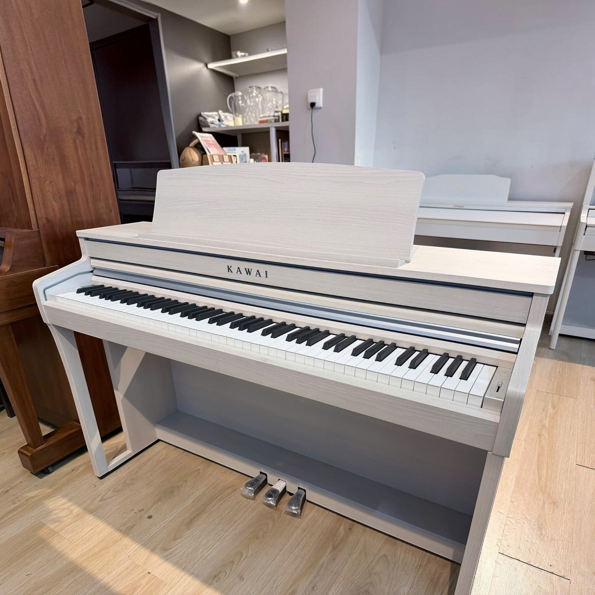 Đàn piano điện Kawai CA49 màu trắng tại Tân Nhạc Cụ, dáng tủ sang trọng với bàn phím gỗ Grand Feel Compact