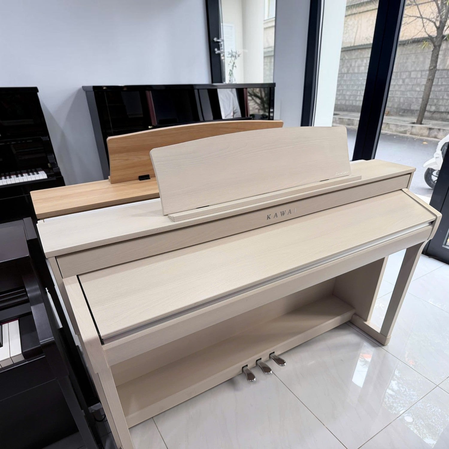 Đàn piano điện Kawai CA78 màu gỗ sáng tại cửa hàng TÂN NHẠC CỤ, thiết kế dáng tủ sang trọng với phím gỗ cao cấp.