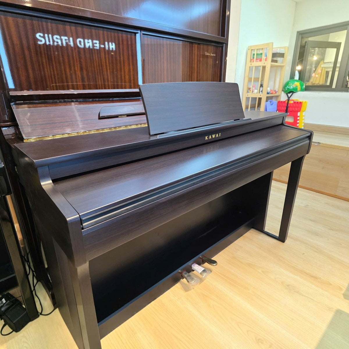 Đàn piano điện Kawai CN201 dáng tủ màu gỗ hồng sắc tại Tân Nhạc Cụ, thiết kế sang trọng với nắp phím trượt.