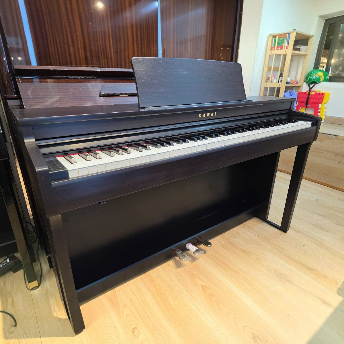 Đàn piano điện Kawai CN201 dáng tủ màu gỗ tối tại Tân Nhạc Cụ, thiết kế 88 phím búa với nắp trượt sang trọng.
