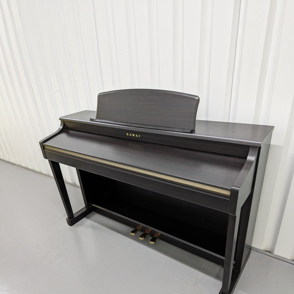 Đàn piano điện Kawai CN33 màu nâu gỗ sang trọng tại TÂN NHẠC CỤ, thiết kế dáng tủ cổ điển với 3 pedal chắc chắn.