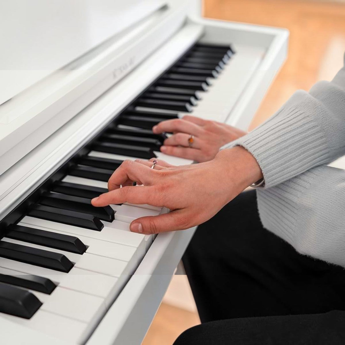 Người chơi đang tập đàn piano điện Kawai CX102 màu trắng với bàn phím búa Responsive Hammer Lite tại Tân Nhạc Cụ