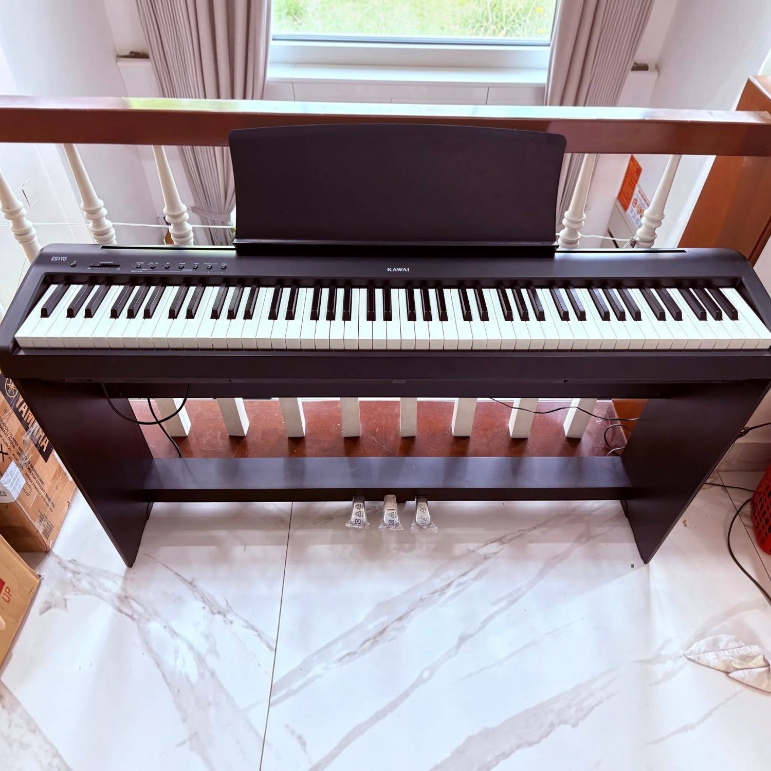 Đàn piano điện Kawai ES110 màu đen tại TÂN NHẠC CỤ, thiết kế di động với 88 phím búa, đặt trên chân đế gỗ chắc chắn.