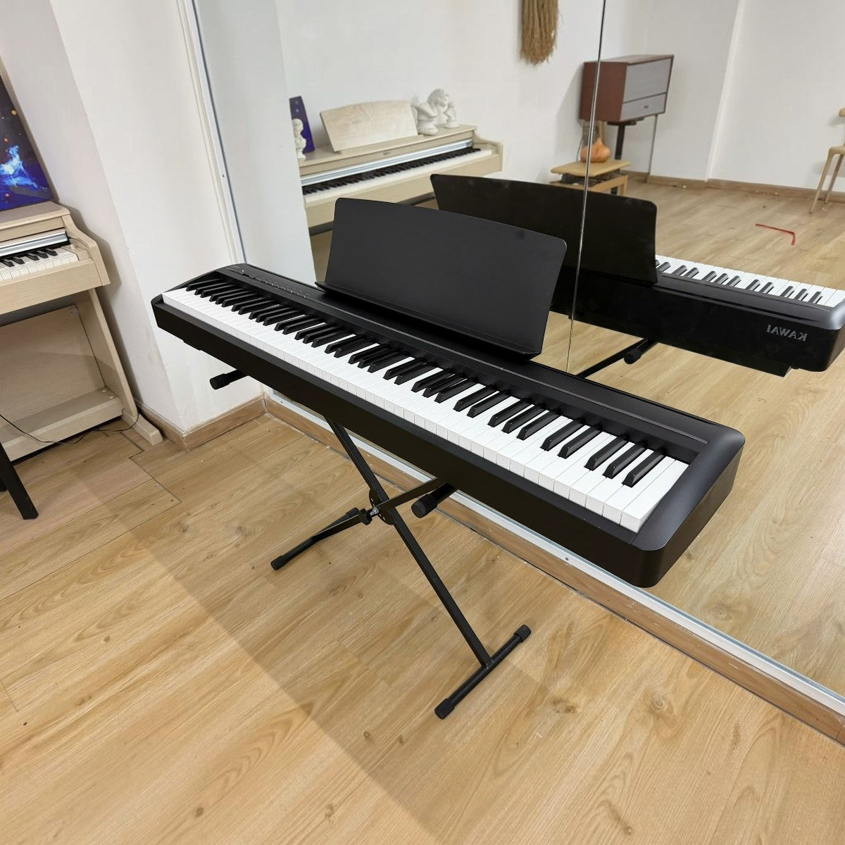 Đàn piano điện Kawai ES120 màu đen tại TÂN NHẠC CỤ, thiết kế gọn nhẹ với 88 phím búa, đặt trên chân đàn chữ X.