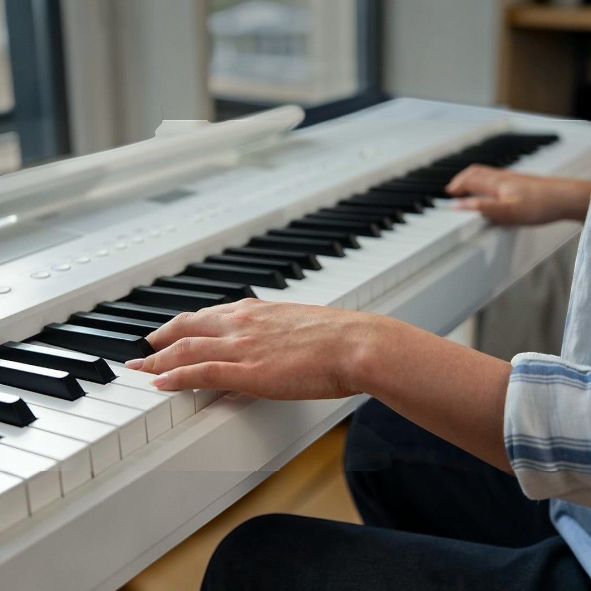Người chơi đang sử dụng đàn piano điện Kawai ES520 màu trắng tại TÂN NHẠC CỤ với bàn phím 88 phím búa nhạy bén