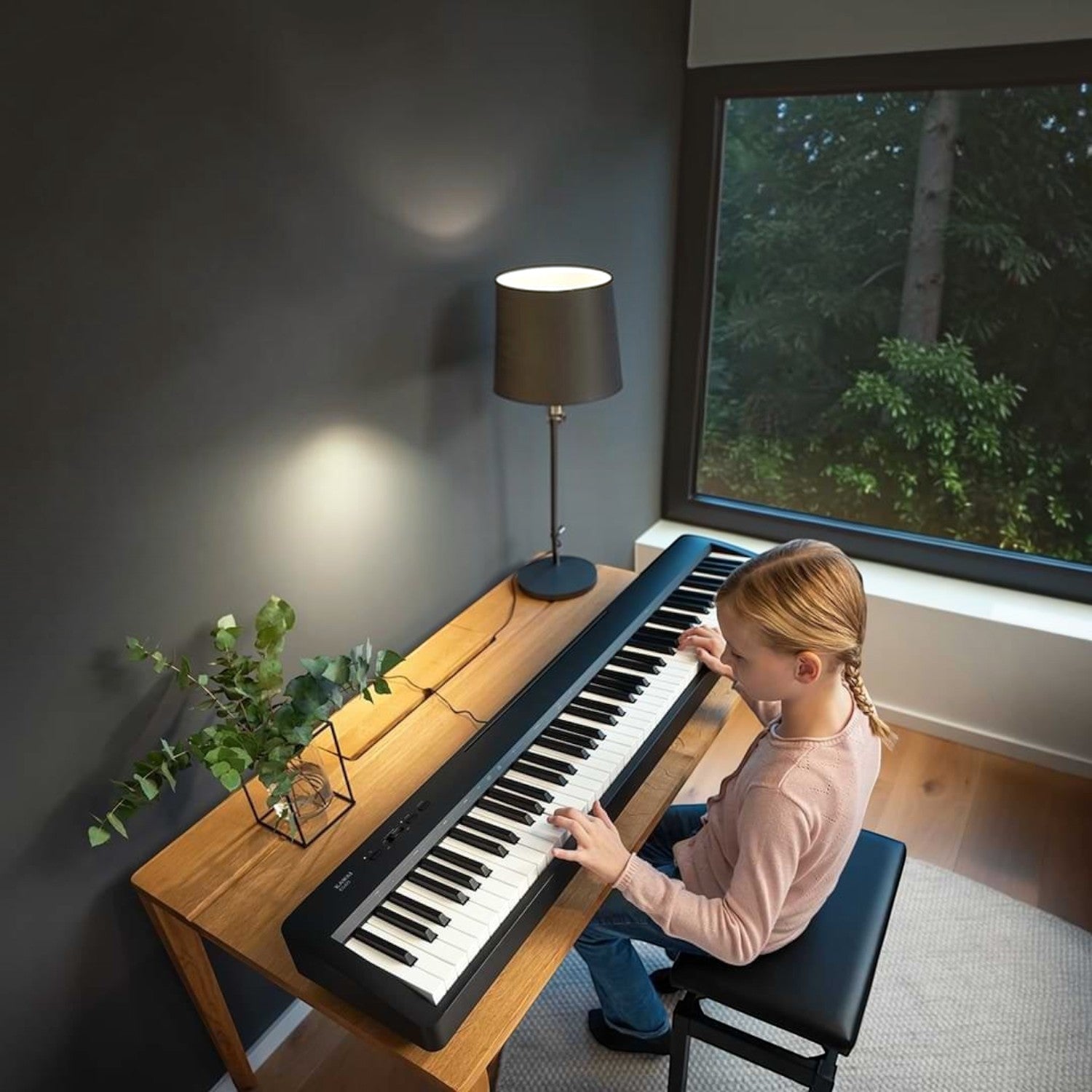 Bé gái đang chơi đàn piano điện Kawai ES60 màu đen tại TÂN NHẠC CỤ, thiết kế gọn nhẹ, bàn phím búa chân thực.