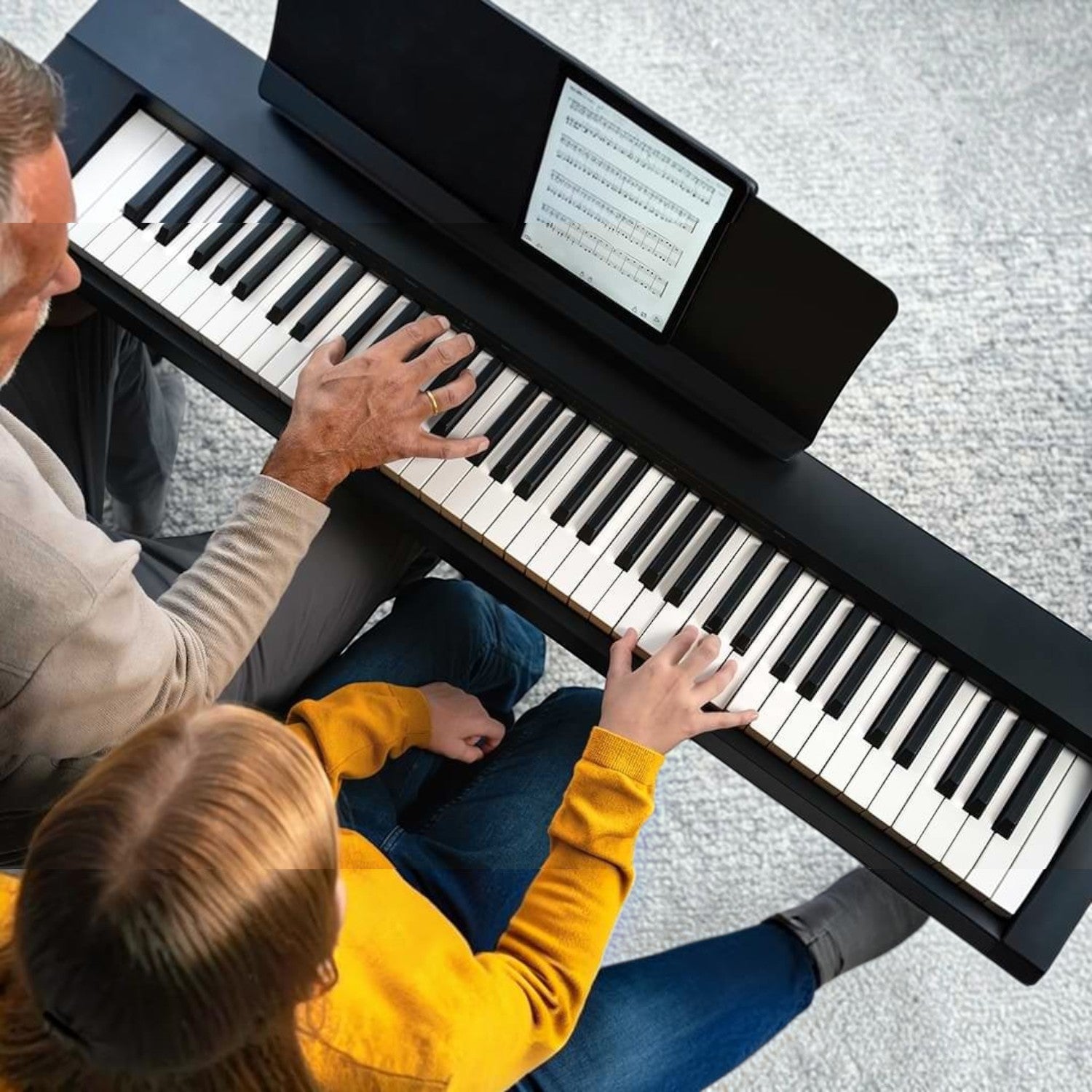 Người lớn hướng dẫn trẻ em chơi đàn piano điện Kawai ES60 màu đen tại Tân Nhạc Cụ