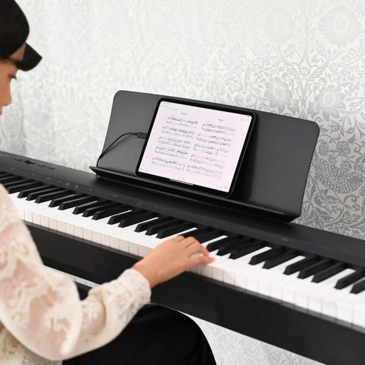 Người chơi đàn piano điện Kawai ES60 màu đen tại TÂN NHẠC CỤ, kết nối máy tính bảng để xem bản nhạc