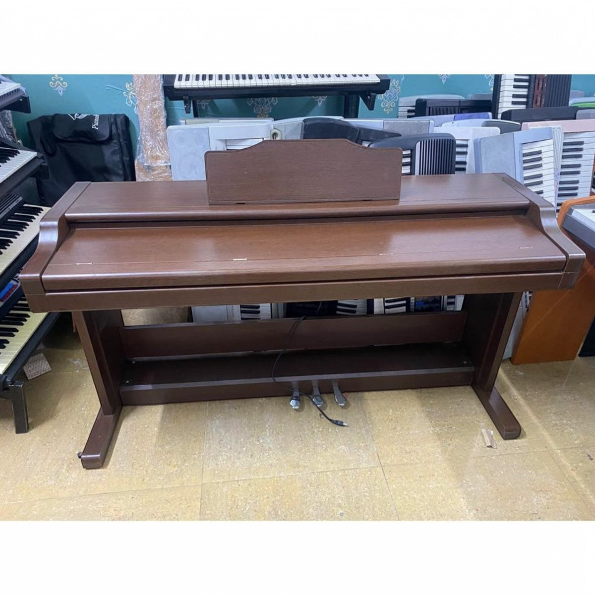 Đàn piano điện TÂN NHẠC CỤ Korg C6000 dáng tủ màu nâu gỗ với 88 phím búa, thiết kế cổ điển gọn gàng.