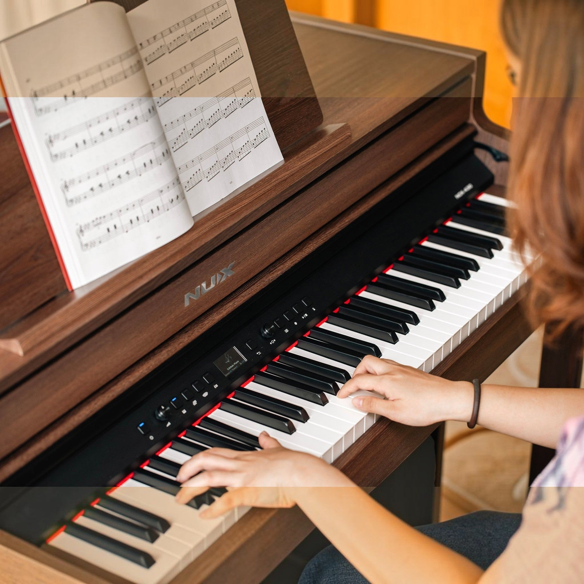 Người chơi đang sử dụng đàn piano điện Nux NCK430 màu gỗ sang trọng tại TÂN NHẠC CỤ với bàn phím hammer-action