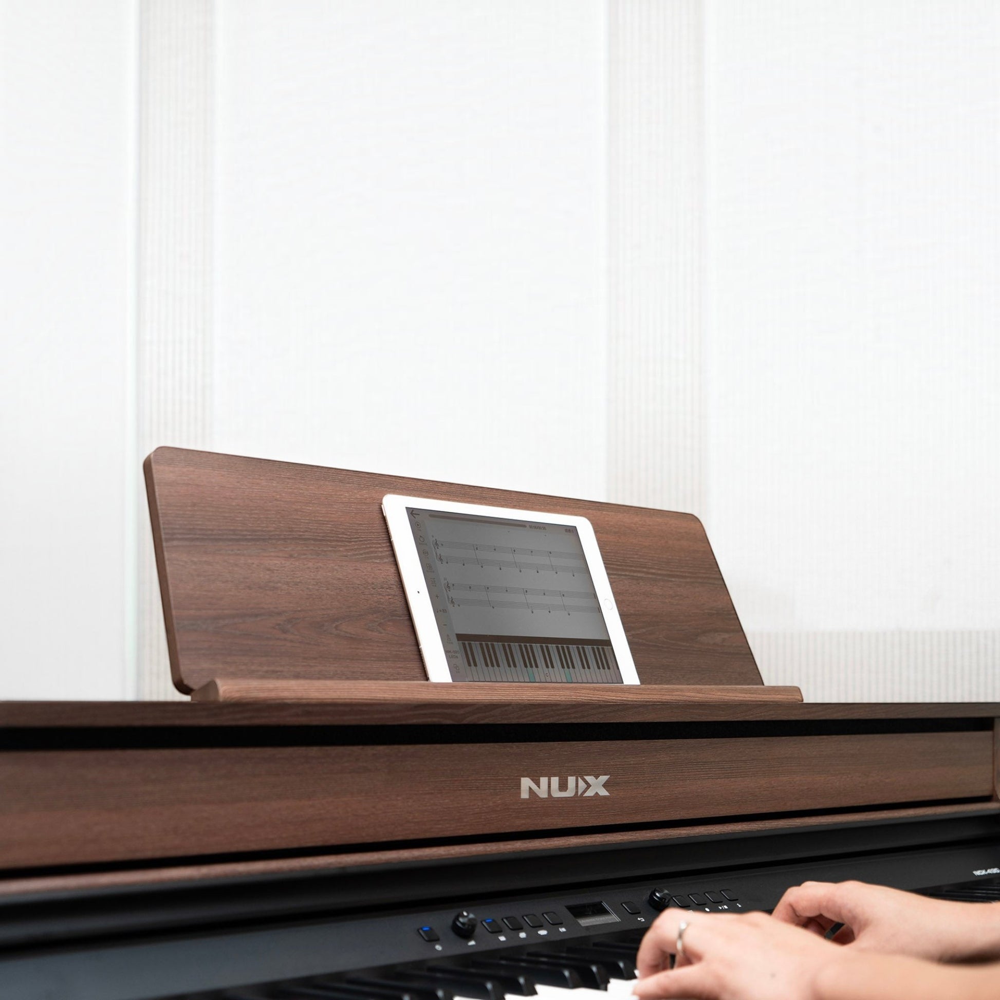 Đàn piano điện Nux NCK430 màu gỗ sang trọng với máy tính bảng đặt trên giá nhạc tại TÂN NHẠC CỤ