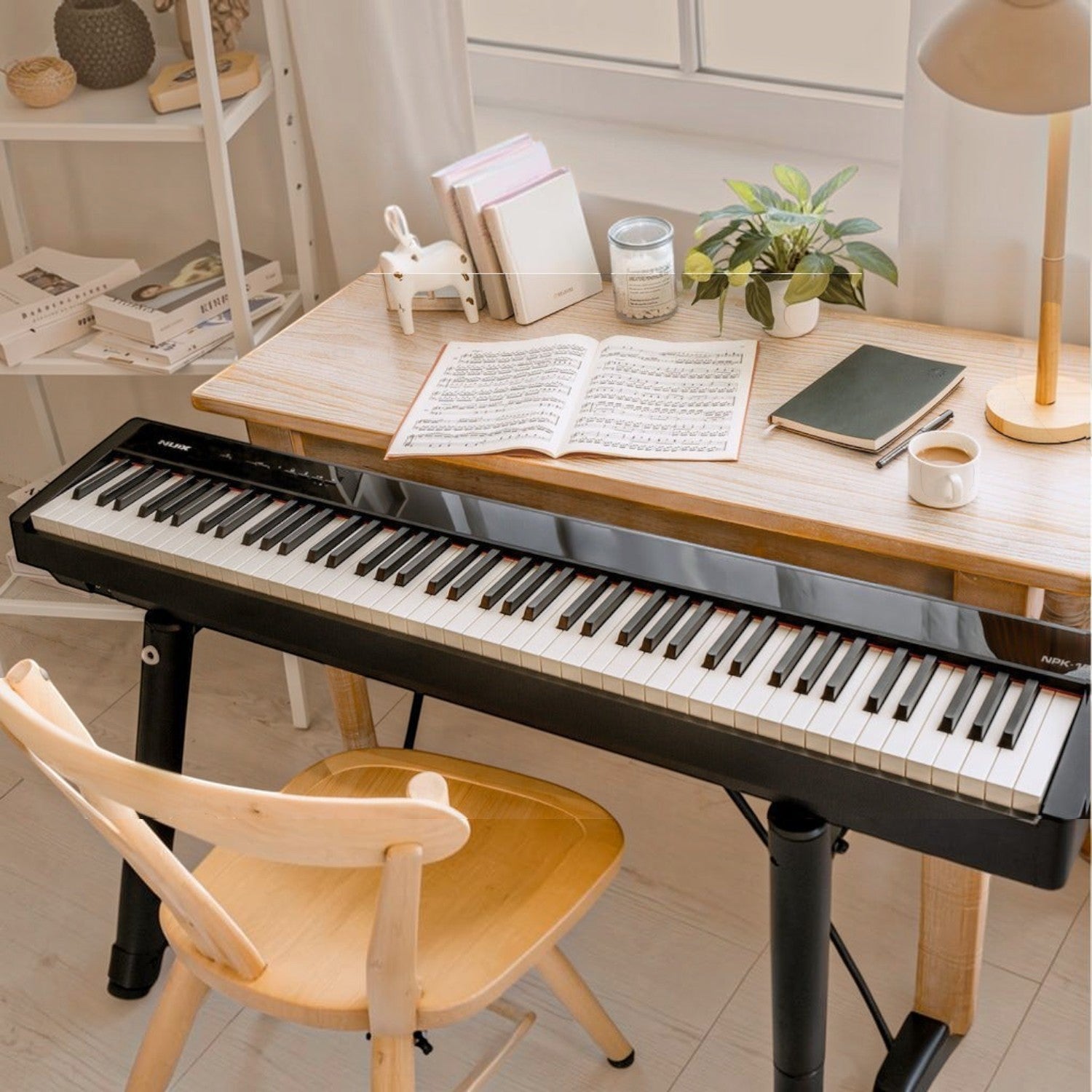 Đàn piano điện NUX NPK10 màu đen với 88 phím búa, đặt trên bàn gỗ trong không gian học tập tại Tân Nhạc Cụ
