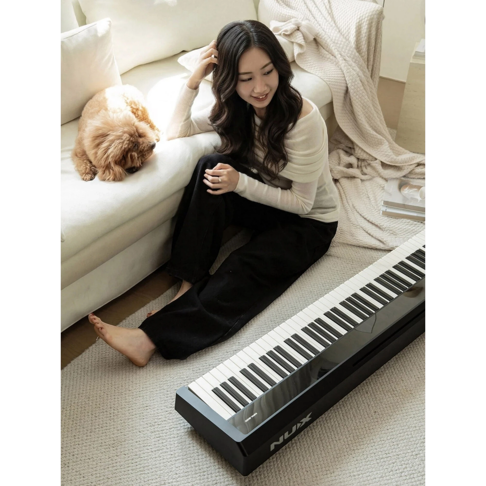 Cô gái trẻ ngồi cạnh đàn piano điện Nux NPK200 màu đen tại Tân Nhạc Cụ, tạo không gian âm nhạc ấm cúng trong nhà.