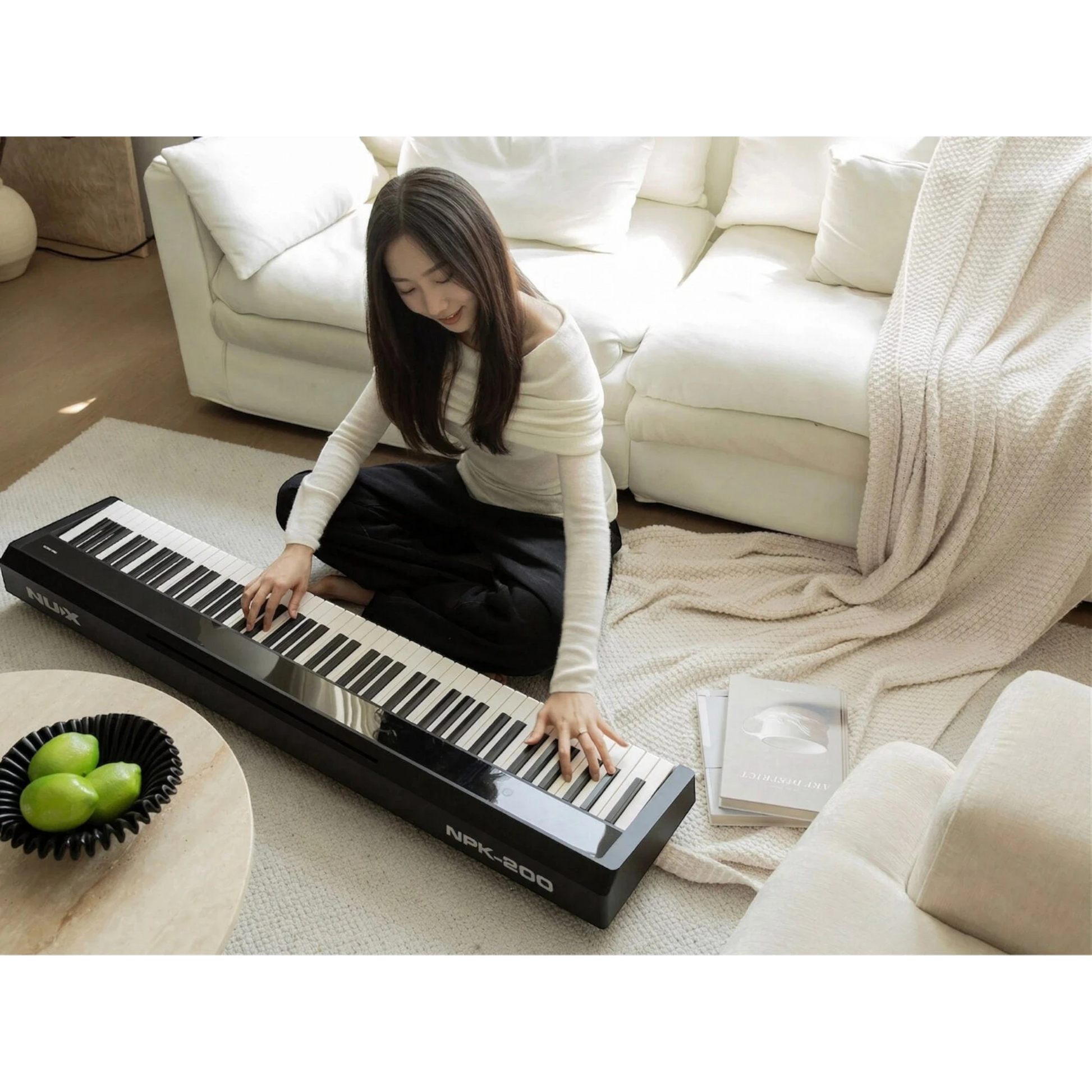 Cô gái trẻ chơi đàn piano điện Nux NPK200 màu đen tại Tân Nhạc Cụ, thiết kế hiện đại trong không gian phòng khách.