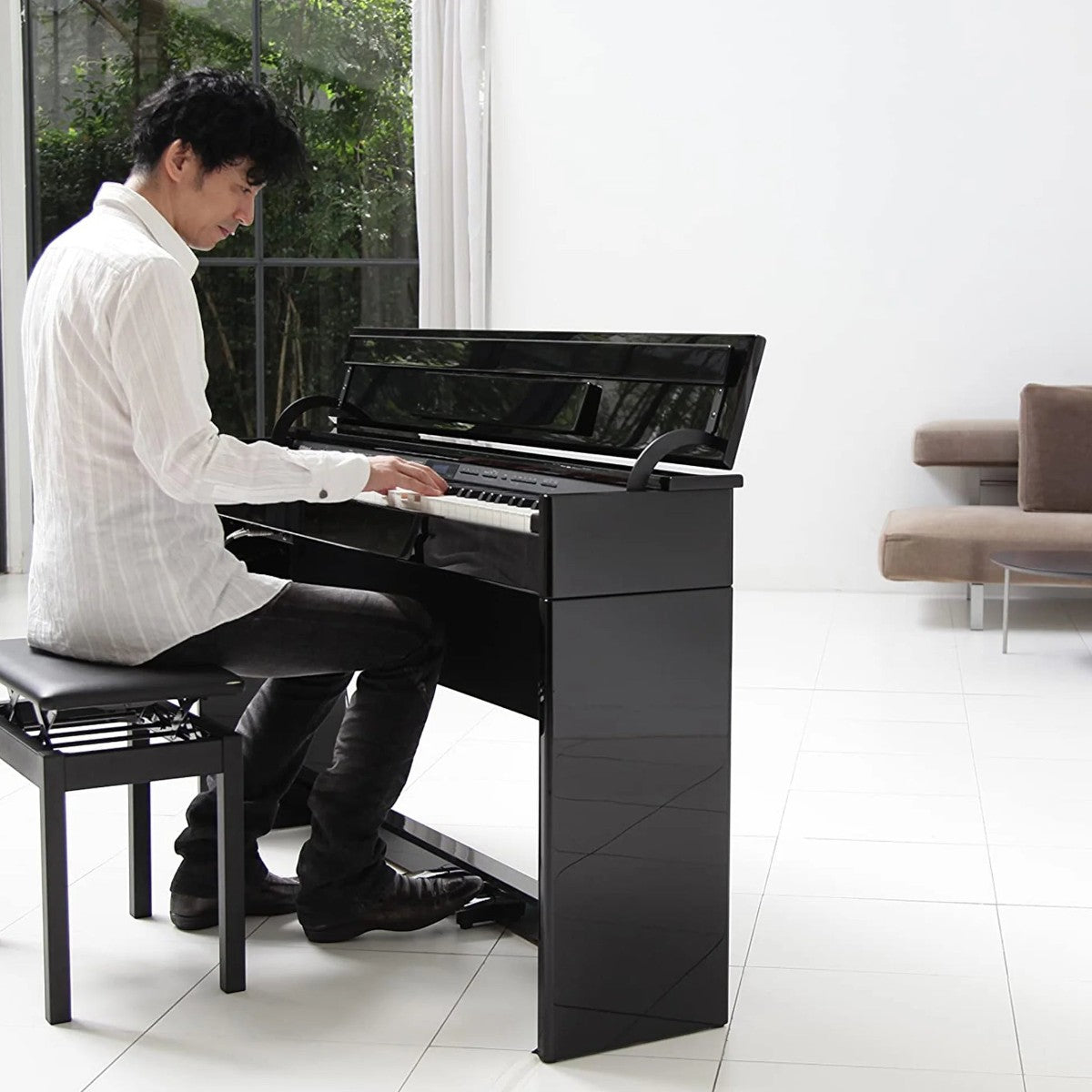 Người chơi đàn piano điện Roland DP603 màu đen bóng tại showroom TÂN NHẠC CỤ với thiết kế dáng tủ mỏng hiện đại