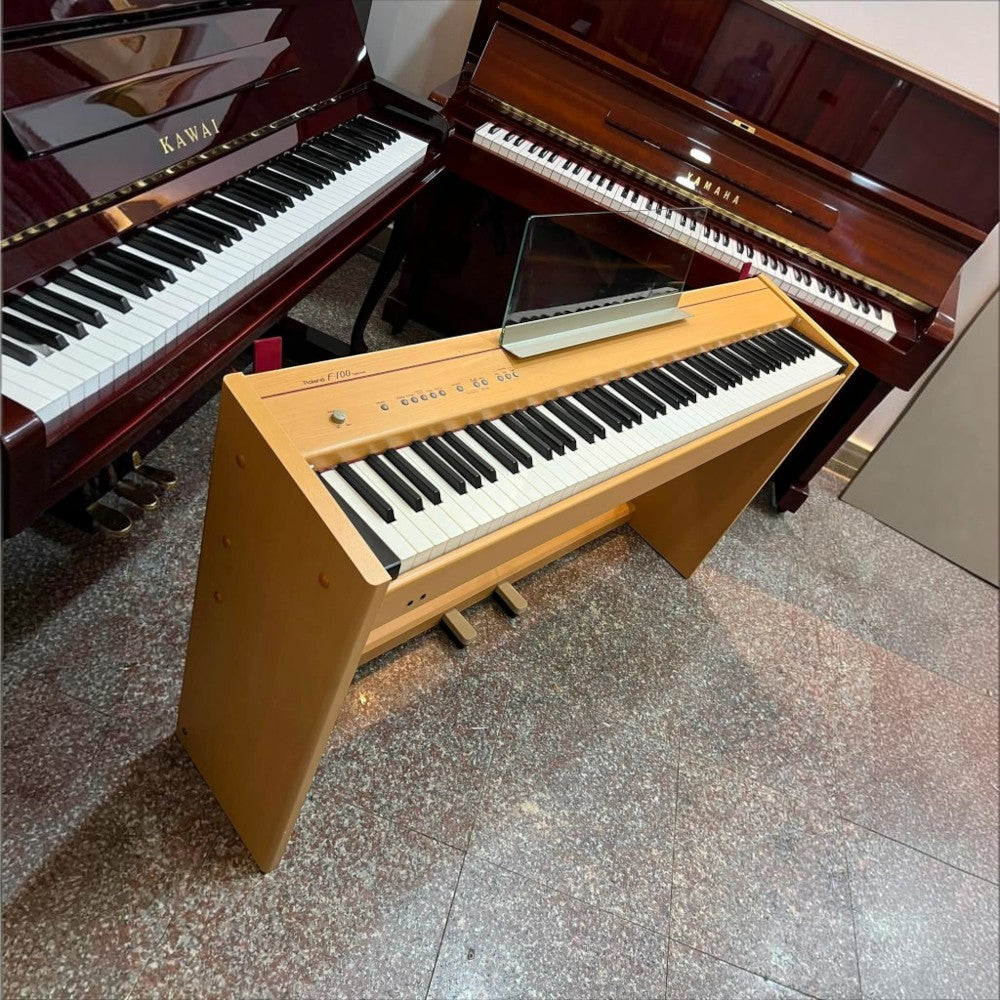 Đàn piano điện Roland F100 màu gỗ sáng tại showroom TÂN NHẠC CỤ, thiết kế dáng tủ gọn gàng với giá nhạc trong suốt