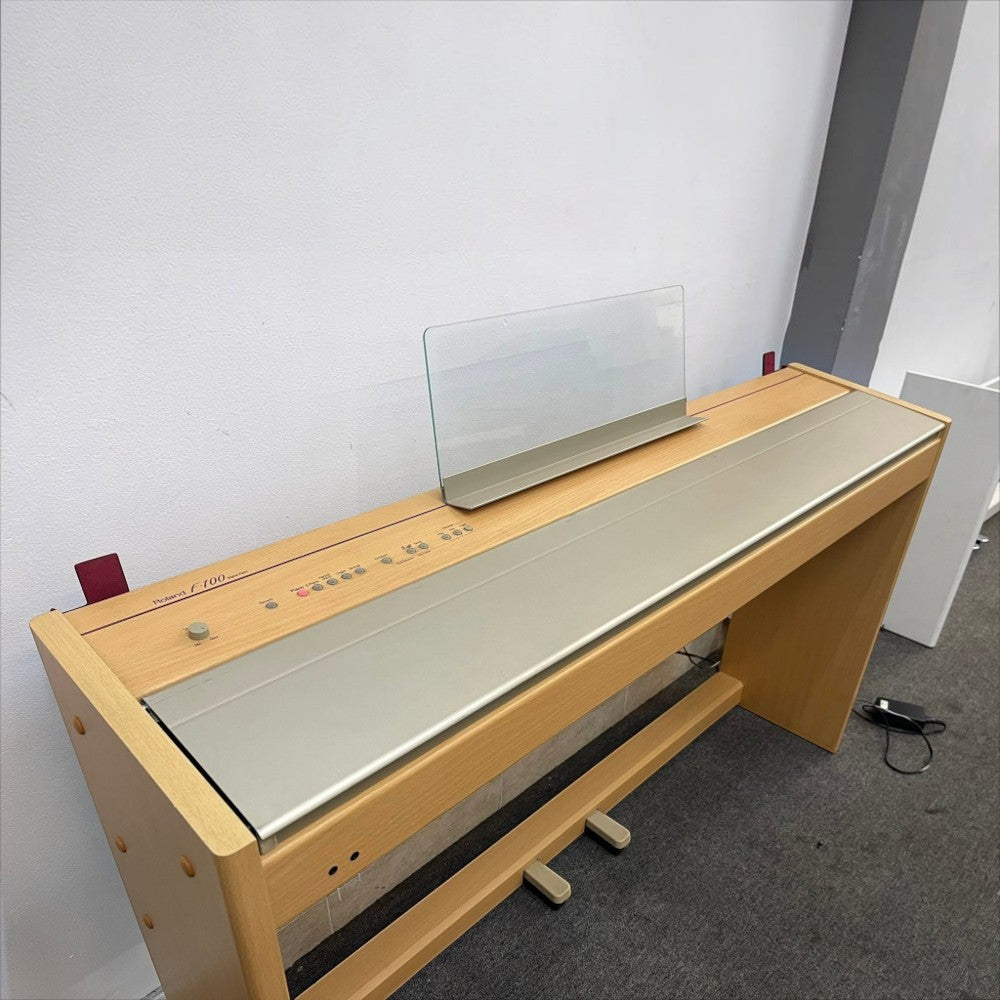 Đàn piano điện Roland F100 màu gỗ thích tại TÂN NHẠC CỤ với thiết kế dáng tủ gọn gàng và giá nhạc trong suốt