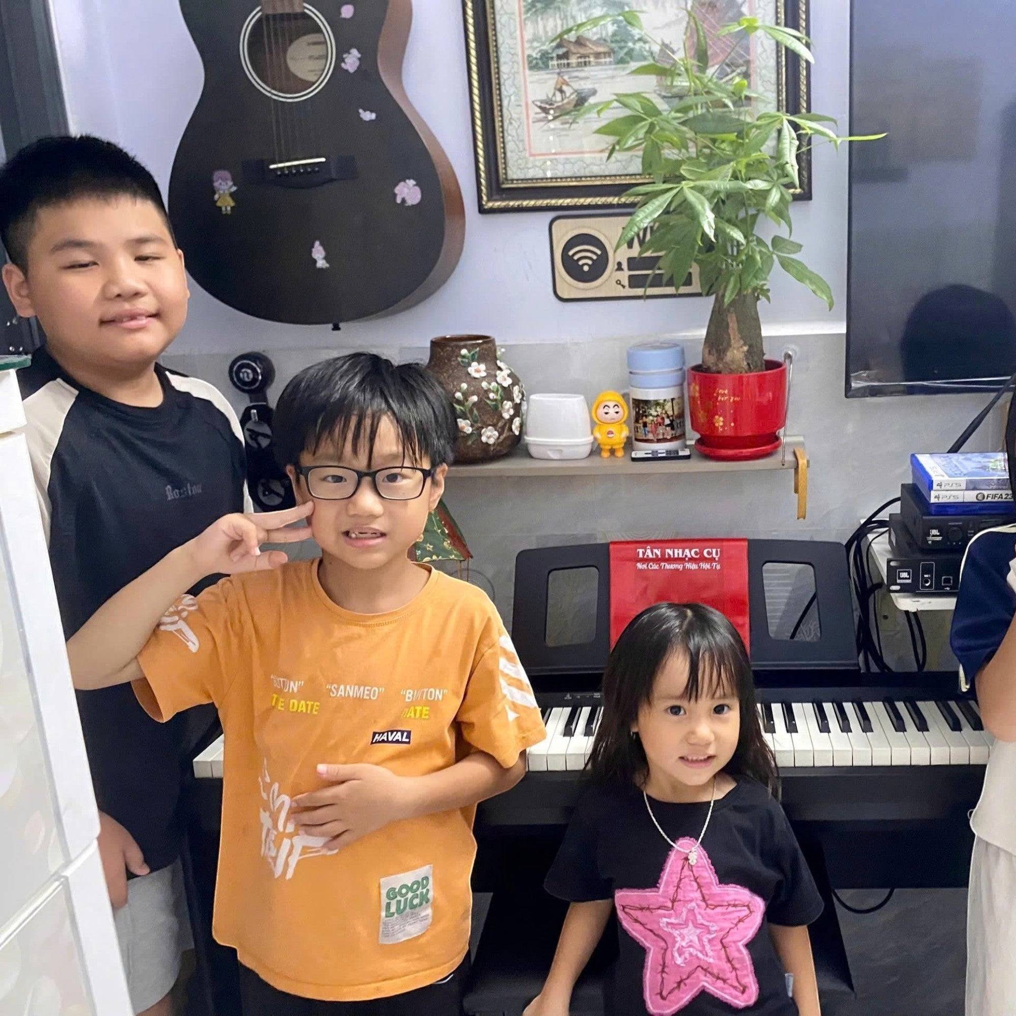Bốn trẻ em tạo dáng vui vẻ bên đàn piano điện Roland FP-10 tại showroom TÂN NHẠC CỤ