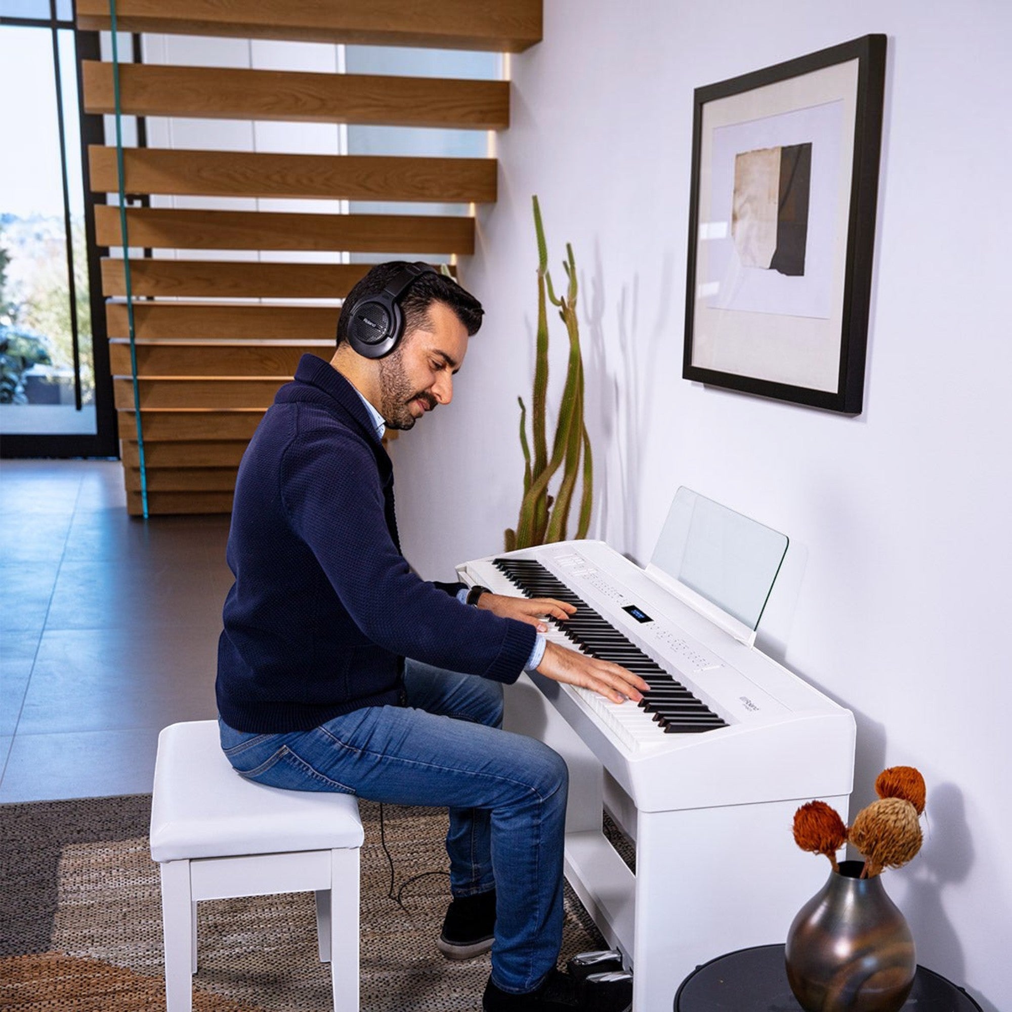 Người đàn ông chơi đàn piano điện Roland FP-60X màu trắng tại nhà, đeo tai nghe, phong cách hiện đại, Tân Nhạc Cụ
