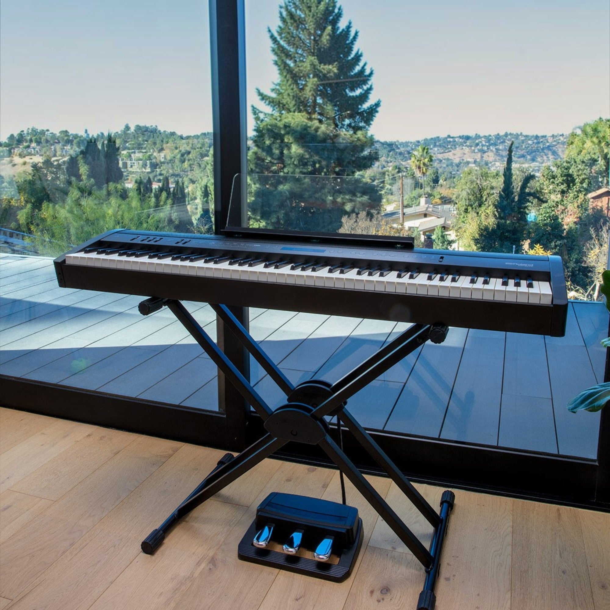Đàn piano điện Roland FP-60X màu đen đặt trên chân đế chữ X cạnh cửa sổ lớn tại TÂN NHẠC CỤ