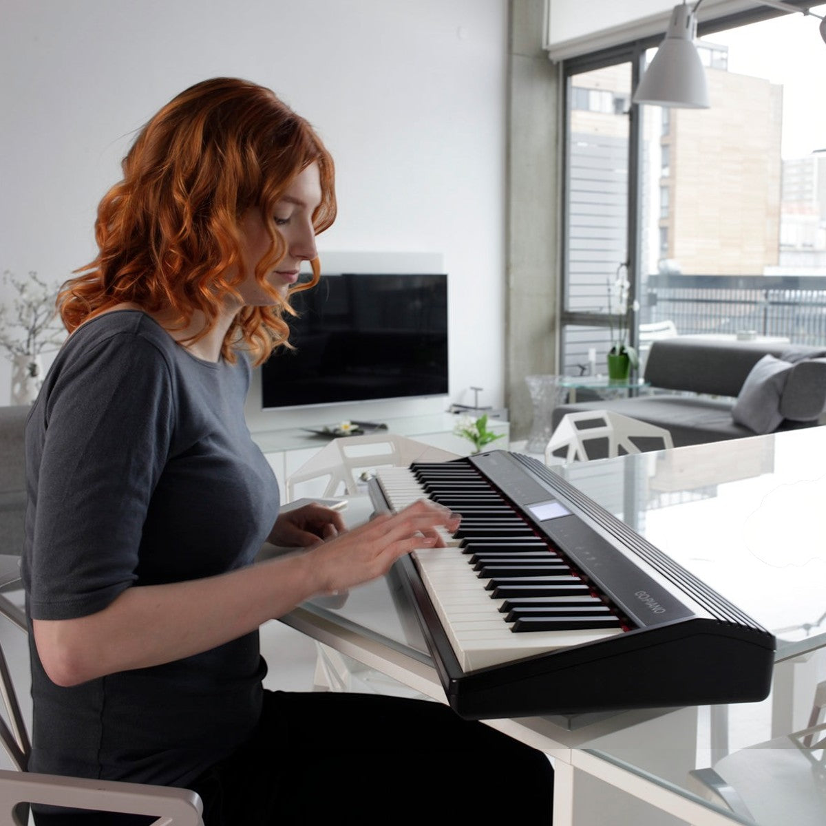 Cô gái tóc đỏ chơi đàn piano điện Roland GO:61 màu đen tại nhà, thiết kế nhỏ gọn, hiện đại của TÂN NHẠC CỤ