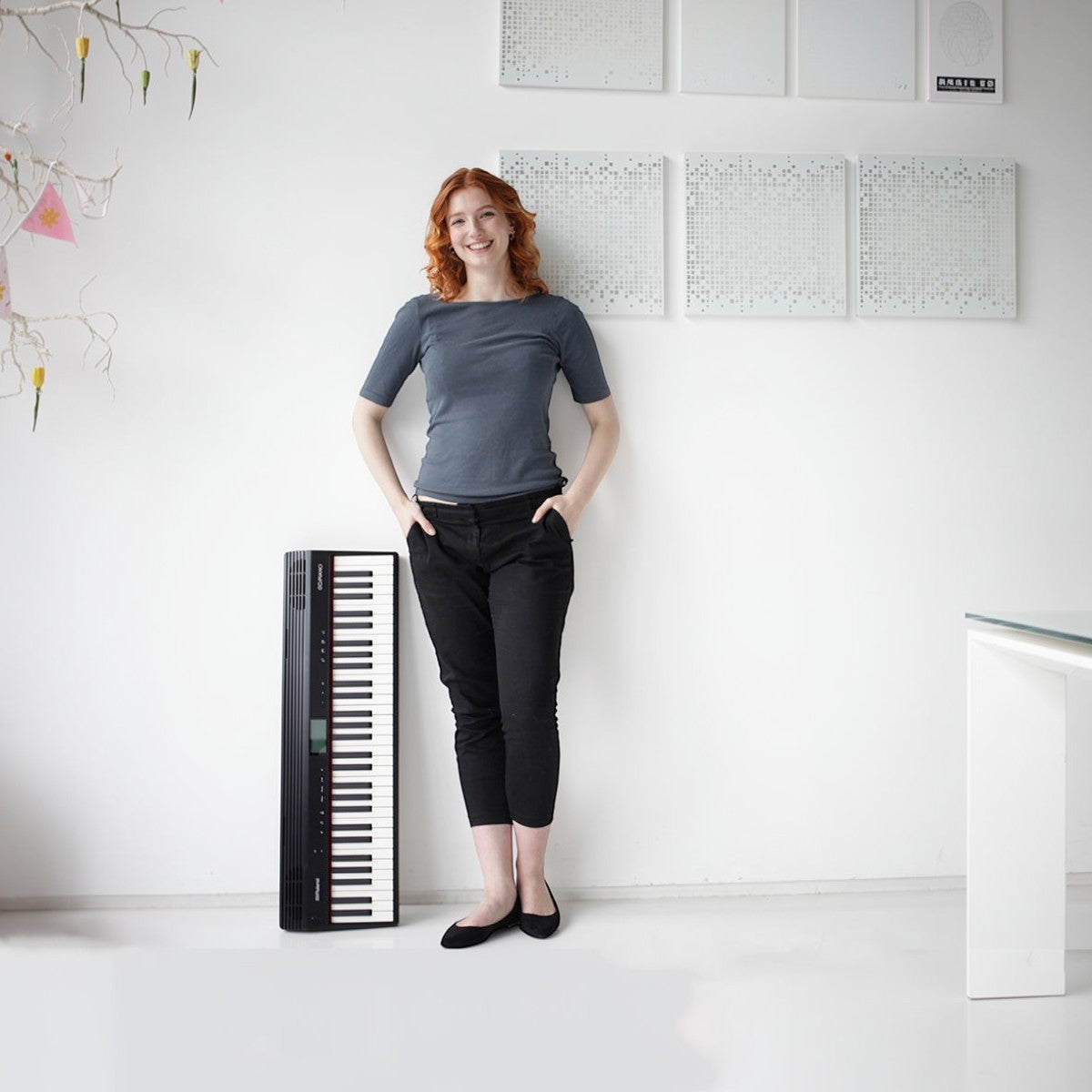 Người phụ nữ đứng cạnh đàn piano điện Roland GO:61 màu đen tại TÂN NHẠC CỤ