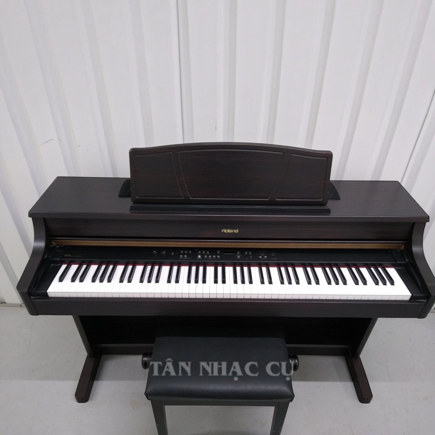 Đàn piano điện TÂN NHẠC CỤ Roland HP107 màu nâu gỗ với thiết kế tủ sang trọng và ghế đàn đi kèm