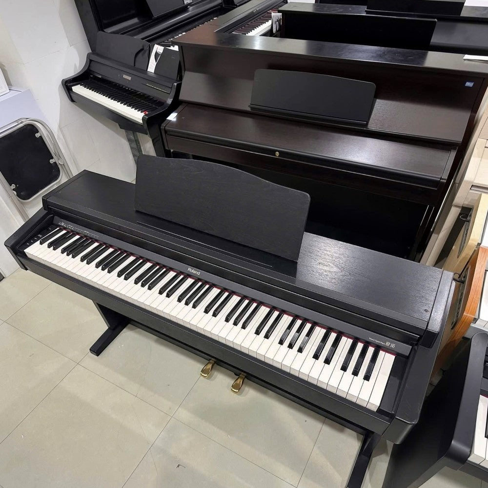Đàn piano điện Roland HP145 màu đen tại TÂN NHẠC CỤ, thiết kế dáng tủ với bàn phím búa 88 phím và 3 pedal.