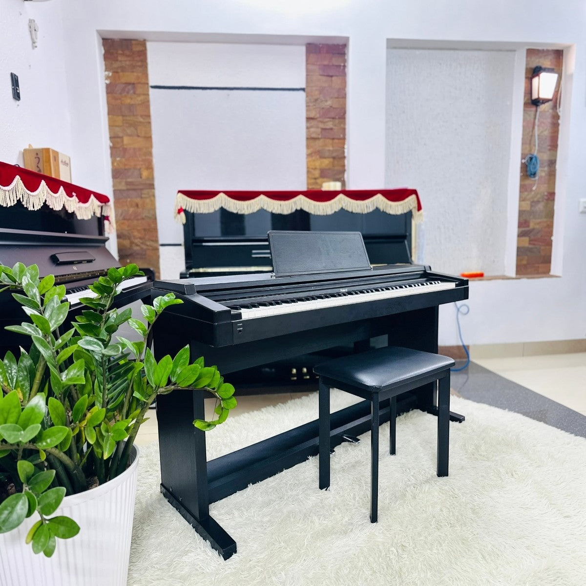 Đàn piano điện Roland HP1700 màu đen dáng console tại showroom TÂN NHẠC CỤ, kèm ghế đàn và chậu cây trang trí