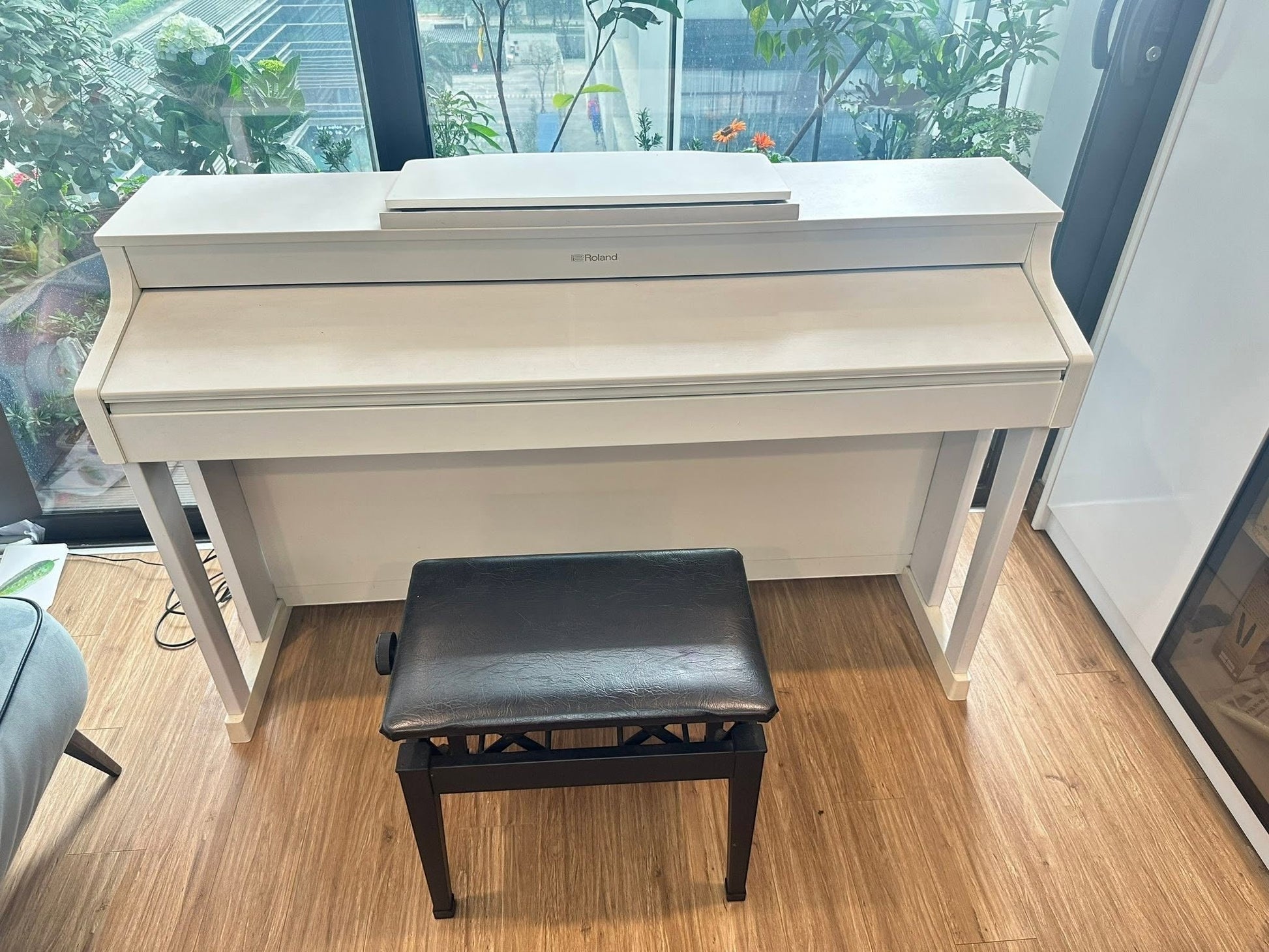 Đàn piano điện Roland HP307 màu trắng sang trọng tại Tân Nhạc Cụ, thiết kế dáng tủ hiện đại với ghế ngồi đi kèm.