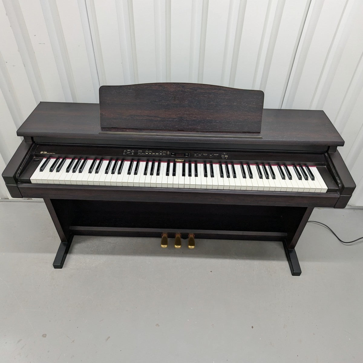 Đàn piano điện TÂN NHẠC CỤ Roland HP330 màu gỗ hồng sắc với thiết kế tủ đứng cổ điển và bàn phím búa weighted.