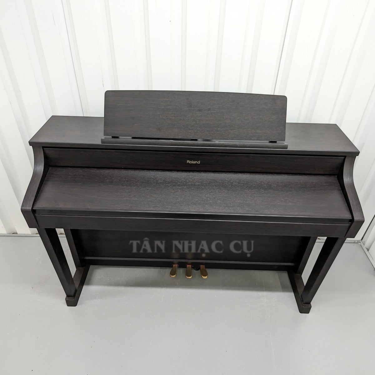 Đàn piano điện TÂN NHẠC CỤ Roland HP-507 màu gỗ mun sang trọng, thiết kế dáng tủ cao cấp với giá đỡ nhạc.