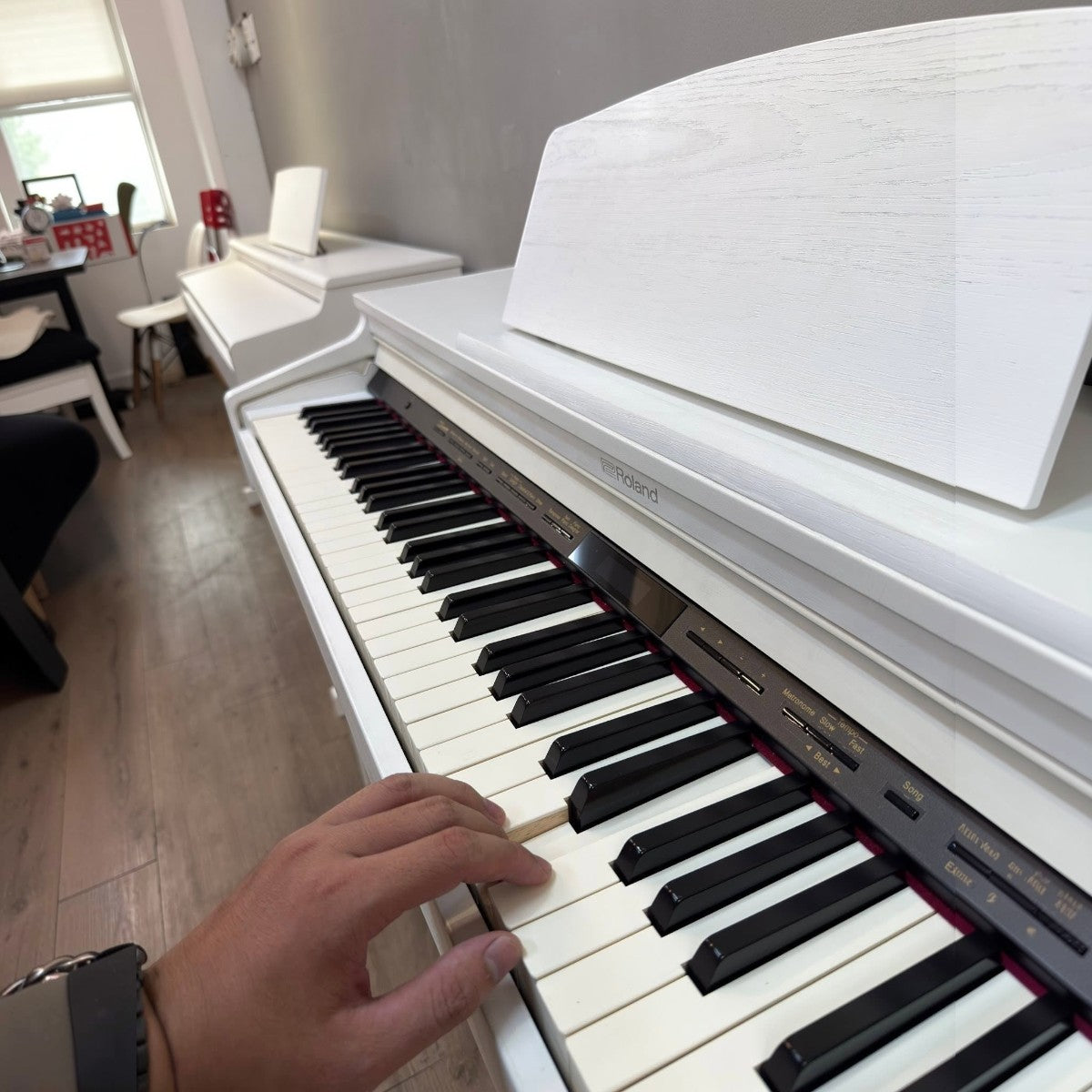 Tay người đang chơi đàn piano điện Roland HP601 màu trắng tại showroom TÂN NHẠC CỤ